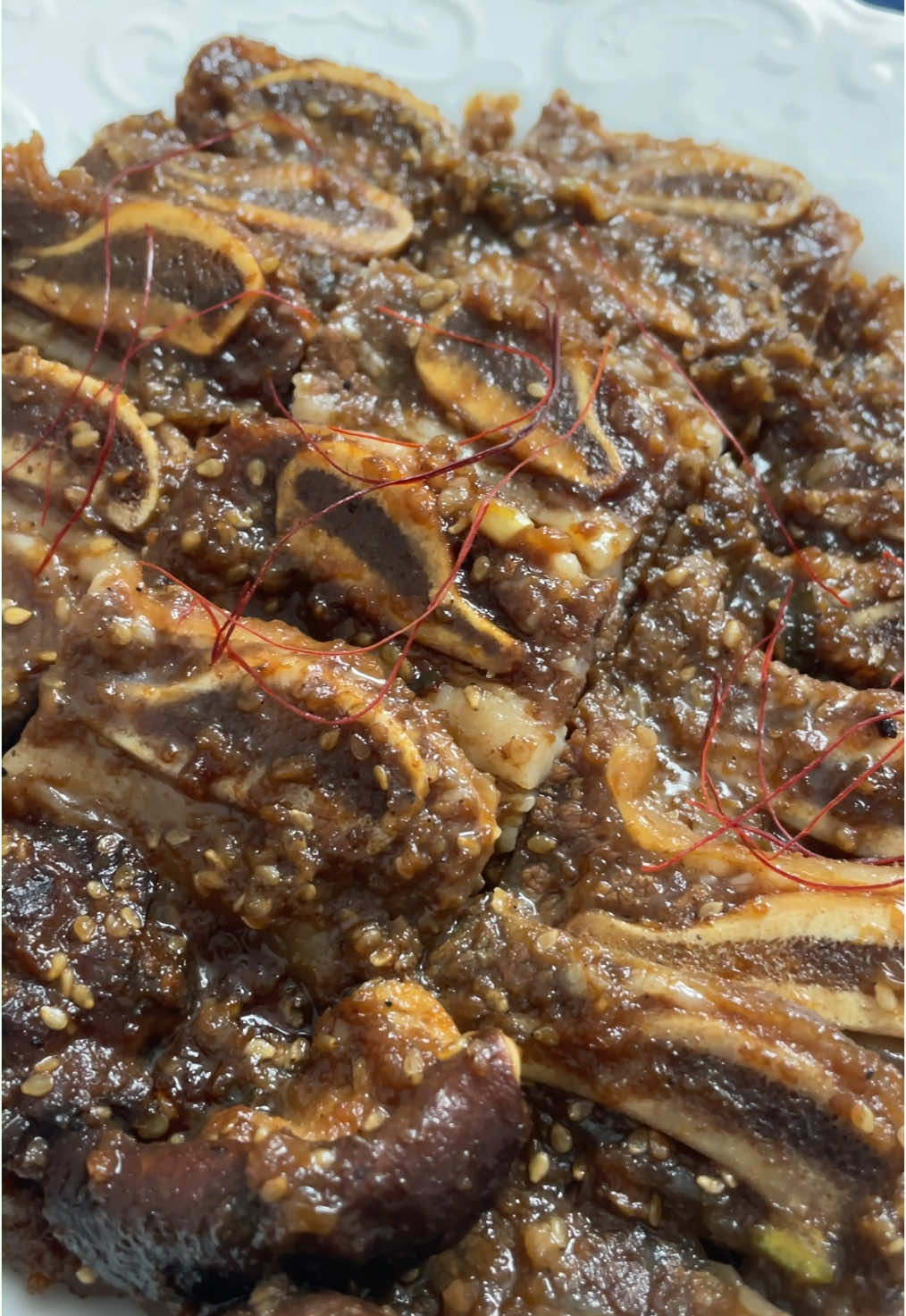 ✨ 다시 돌아온 LA 양념 갈비 ✨ 어느덧 설 명절이 다가왔네요.  오늘은 명절에 먹으면 더 맛있는 LA갈비 레시피를 가져왔어요! 💕 이 레시피의 포인트는 바로 맛있게 굽는 꿀팁에 있어요! 🙌 👩‍🍳 양념의 황금비율부터 갈비를 맛있게 굽는 방법까지, 하나하나 쉽고 간단하게 알려드릴게요! 이번 설 전에 미리 양념에 재워 두셨다가, 가족들과 맛있게 구워 드셔서 행복한 시간 만들어 보세요. 💖🍖✨ *이 영상은 세종글꽃체를 사용하여 제작하였습니다. ======================= 🥄 계량 : 종이컵(200ml), 밥스푼, 티스푼  🍖 재료 - LA갈비 2kg - 표고버섯 5개 - 사과 1개 - 배 1/2개 - 양파 1/2개 🥫 양념 - 청주 1cup - 흑설탕 5T - 참깨 1/3cup - 진간장 1cup - 참기름 1/3cup - 다진마늘 1/2cup - 다진파 1/2cup - 조청 1/3cup - 후추 1t - 물 1/2cup ✅ 만드는 법 1. 갈비를 물에 넣어, 30분동안 핏물을 뺀다. 2. 흐르는 물에 씻어, 뼛조각을 제거한다. 3. 사과, 배, 양파를 잘게 썰어 블렌더에 간다. 4. 3을 양념에 잘 섞는다. 5. 갈비를 통에 층층이 담고, 위에 양념을 중간 중간 뿌려준다. 6. 냉장고에 24시간 숙성한다. 7. 맛있게 구워서 냠냠! 📌 쿠킹팁 - 양념을 만들 때 흑설탕, 조청이 녹을 때까지 충분히 저어주세요.  - 좀 더 진한 갈색을 내기 위해 흑설탕을 사용해 주세요. - 청주를 넣으면 좀 더 고급진 향을 낼 수 있어요. - 조금 더 부드러운 고기를 위해서, 파인애플 링 한 개나 키위 한 개를 넣어주세요. 파인애플이나 키위를 많이 넣으면 고기가 물러질 수 있으니 조심하셔야 돼요.  - 사과 반개를 넣으면 딱 적절한 씹는 맛을 살릴 수 있어요. - 고기를 구울 때, 영상에서 설명한대로 따라서 해보시면, 훨씬 부드럽고 깊은 맛을 낼 수 있어요. - 약불에서 은근하게 구워야 뼈와 살이 부드럽게 분리가 되요. - 2판을 굽고 팬의 양념을 제거하고, 다시 구워주세요. 너무 짜져요. ================= Korean BBQ LA galbi (LA-style short ribs) 🍖 Ingredients - 2kg LA-style short ribs - 5 shiitake mushrooms - 1 apple - 1/2 pear - 1/2 onion - 1 cup rice wine (cheongju) - 5T dark brown sugar - 1/3 cup sesame seeds - 1 cup soy sauce - 1/3 cup sesame oil - 1/2 cup minced garlic - 1/2 cup chopped green onions - 1/3 cup corn syrup - 1t black pepper - 1/2cup water ✅ Directions  1. Soak the ribs in water for 30 minutes to remove excess blood. 2. Rinse under running water to clean and remove any bone fragments. 3. Chop the apple, pear, and onion into small pieces, then blend until smooth. 4. Mix the blended fruit and onion with the rest of the marinade ingredients. 5. Layer the ribs in a container, adding marinade between each layer. 6. Refrigerate and let it marinate for 24 hours. 7. Grill to perfection and enjoy! 📌 Cooking Tips - Stir the marinade well until the dark brown sugar and corn syrup are fully dissolved. - Use dark brown sugar for a richer color and deeper flavor. - Adding rice wine gives the dish a more refined aroma. - For extra tenderness, add one slice of pineapple or a piece of kiwi, but be cautious—too much can overly soften the meat. - Half an apple is the perfect amount to maintain a good texture in the ribs. - When grilling the meat, follow the steps explained in the video to achieve a much more tender and flavorful result. - Grill over low heat to gently separate the meat from the bone, making it tender and easy to enjoy. - After grilling two batches, clean the pan of any remaining sauce before starting the next. Otherwise, the meat might turn out too salty. #함요 #함께하는즐거운요리 #LA갈비 #LA갈비레시피 #LA갈비만들기 #명절음식 #명절고기요리 #설요리 #설음식 #추석요리 #추석음식 #소갈비 #양념소갈비 #갈비요리 #쉬운고기요리 #홈쿡 #꿀팁공유 #맛있다그램 #집밥스타그램 #요리스타그램 #먹스타그램 #FunCookingTogether #EasyKoreanBBQ #LAGalbi #KoreanShortRibs #HolidayCooking #FamilyMeals #KoreanBBQRecipe #LunarNewYearFood #ChuseokRecipes #BeefRibs #GrilledShortRibs #QuickAndEasyBBQ #DeliciousMeals #HomeCookingTips #FoodieLife #KoreanFoodLove #BBQGoals