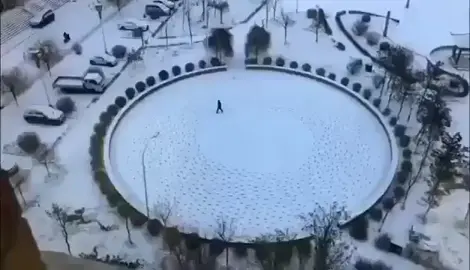 Bored man creates circular pattern while walking in snow.