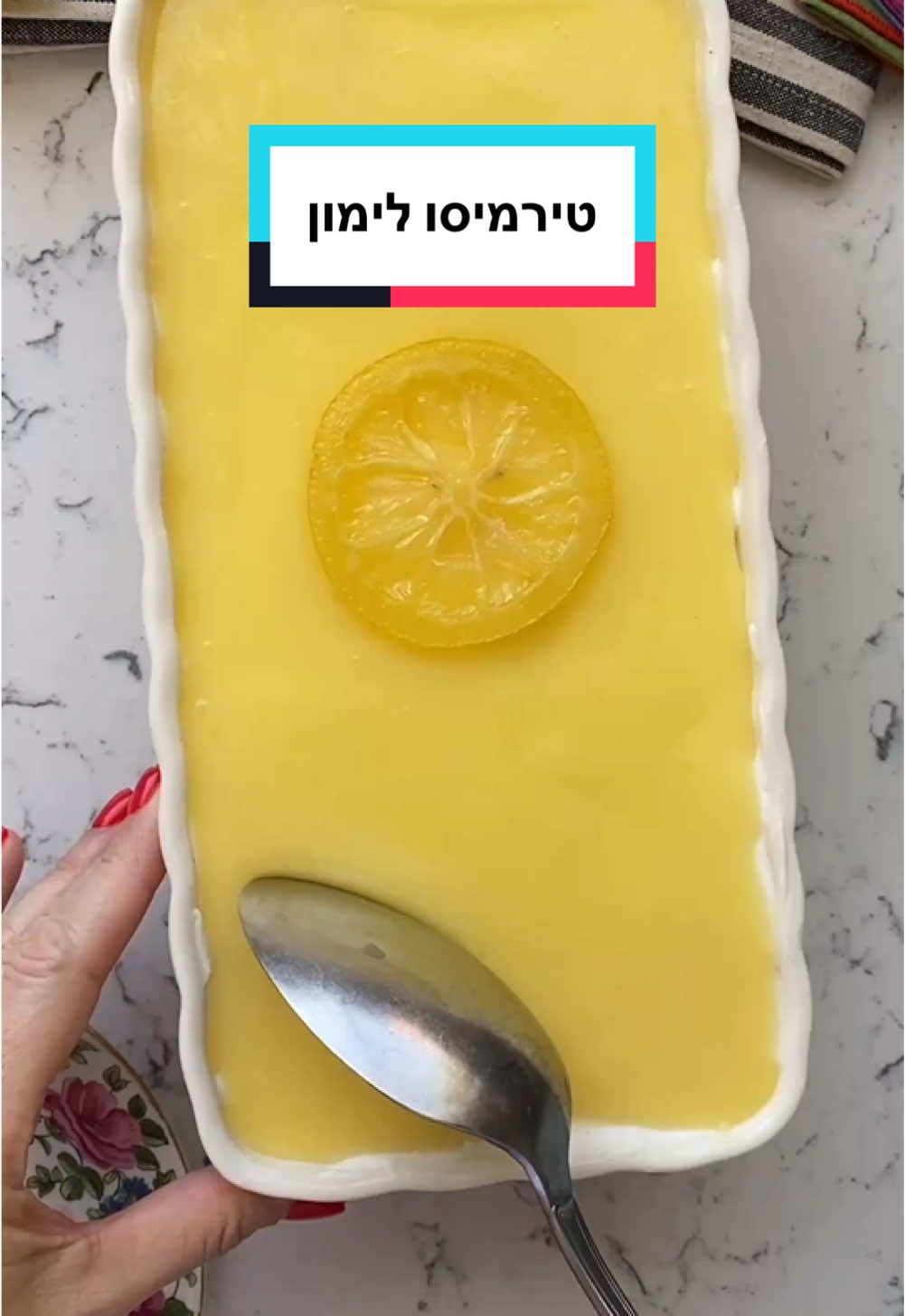 מתכון לטירמיסו לימון, או: כשטירמיסו ופאי לימון נפגשים 💛 קינוח מטורף ופשוט להכנה! מרכיבים קרם לימון פטנט 5 חלמונים מדיום 1 כוס (200 גרם) סוכר 2 כפות גדושות קורנפלור 1 כוס (240 מ״ל) מיץ לימון טרי גרידה מ-2 לימונים גדולים 100 גרם חמאה חתוכה לקוביות לקרם גבינה 2 מכלי שמנת מתוקה 38% קרה מאד (500 מ״ל סה״כ)  1 גביע גבינה לבנה ⅓ כוס סוכר 1 כפית תמצית וניל גרידה מלימון שלם להרכבה חבילת בישקוטים ½ כוס חלב, אולי טיפה יותר 1 כפית תמצית וניל לקישוט (לא חובה אפשר פשוט לשים דובדבן) פרוסת לימון רבע כוס סוכר רבע כוס מים אופן ההכנה (אל תבהלו מהאורך באמת זה קל) מתחילים מהקרם לימון כי הוא צריך להתקרר מעט קרם לימון: מכינים קערה שעלייה יש מסננת. שמים בסיר קטן חלמונים וסוכר ומערבבים. מוסיפים את כל שאר החומרים. מבשלים הכל יחד כ5-10 דקות על אש קטנה-בינונית תוך ערבוב מתמיד, עד שהתערובת מתחילה להסמיך. (אני שמה כיסא ליד הכיריים ועם סבלנות רבה בוחשת ובוחשת עד שזה קורה). ברגע שמתחילים להרגיש שהתערובת נהיית במקרם של יוגורט/פודינג, מכבים את האש. מעבירים את הקרם דרך מסננת לתוך הקערה.  מכסים בניילון נצמד שצמוד לפני הקרם (כדי שלא יווצר קרום) ומקררים עד השימוש (כחצי שעה לפחות) שכבת קצפת: בקערת מיקסר עם וו הקצפה שמים את כל מרכיבי שכבת הקרם ומקציפים לקרם אחיד ויציב. מתחילים מהקצפה איטית כדי שהחומרים יתאחדו והגבינה תתרכך. הרכבה: טובלים כל בישקוט בחלב ומסדרים בתחתית התבנית.  מניחים על הבישקוטים חצי מהקרם ומורחים אותו לשכבה אחידה. מורחים מחצית מהקרם לימון. טובלים שוב ביסקוויטים בחלב ומניחים על הקרם לימון, ושוב מורחים את המחצית השנייה של הקרם. הפסקת קירור והתייצבות עוטפים בניילון נצמד (אם זה לא פוגע בקרם, אם כן אז אל תעטפו) ומצננים לפחות שעתיים. לפני ההגשה מקשטים בבפירות או בלימון מסוכר. ללימון:  בקלחת קטנה הבאתי לרתיחה סוכר ומים ובישלתי כחמש דקות. נוספתי את פרוסת הלימון ובישלתי עוד חמש דקות. מוציאים את הפרוסה לחתיכת נייר אפייה (לכל דבר אחר הוא ידבק) ומקשטים את העוגה. #אפרתליכטנשטט #טירמיסו #לימון 