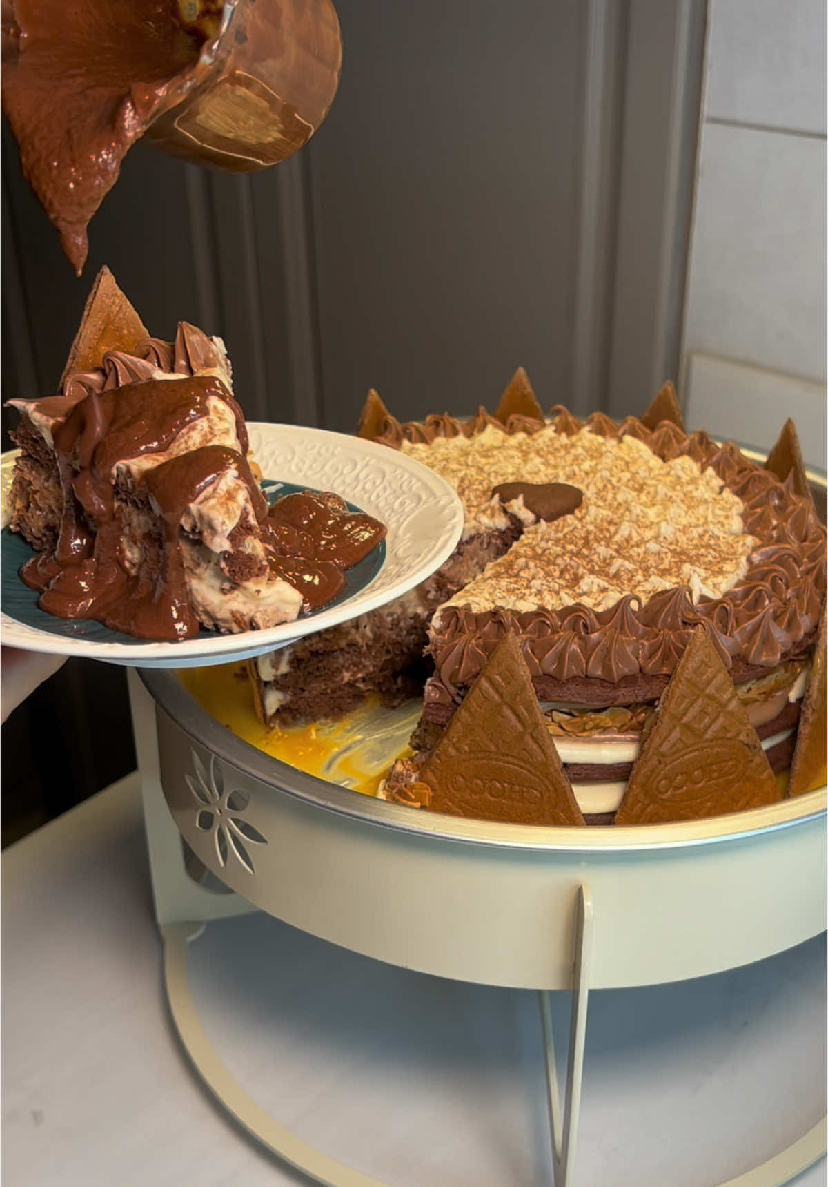 سخان طبقات كيك بحشوة التشوكلت والكريمة ❤️‍🔥   للكيكة :  ‏ 180g زبدة  ‏ 100g سكر  ‏ 120g عسل  في حمام مائي لين يذوب السكر بعدها اضيف ملعقه صغيرة بيكربونات الصوديوم واخلطه واتركه حتى يبرد بعدها اضيف   2 بيضتين + فانيلا  ‏ 400g دقيق ‏ 40g تشوكلت باودر   - ضروري ننخل المكونات الجافة -  اعجنها واخليها بالثلاجه ساعتين   خبزتها على حرارة 160 فوق وتحت كل طبقة تأخذ 8 دقائق  بعد ماطلعتها من الفرن اغلفها بنايلون عشان ما تنشف الحشوات اختيارية تقدرون تحشونها بأي شي  حشوة الكريمة البيضاء :  ‏60g زبدة بحرارة الغرفة + 3/4 كوب سكر بودرة وفانيلا  خلطتهم بعدين اضفت عليهم 200g جبن كريمي وخفقتها لين صارت كريمية  قاناش التشوكلت :   على النار سخنت 220g كريمة خفق  صبيتها على 300g تشوكلت  تخلونها اربع دقايق بعدها تخلطونها وتحطونه بالثلاجة اقل شي ساعتين  بعدها بالخفاقة الكهربائية لين تصير بقوام متماسك  طبقة المكسرات :   1 كوب ونصف لوز صنوبري ومبشور + 3/4 كوب بودرة الفلورنتين اخلطه وارصه بصينية وادخله الفرن من فوق وتحت حتى يتماسك ويتشقر👍🏼  جميع الأغراض والسخان بالفيديو أخذتها من محل (مستلزمات أودن حلا ) موجود في القصيم بريدة وعندهم متجر يوصل لجميع مناطق المملكة   هذا حسابهم @أودن حلا  #سخانات #حلا #حلى #اكسبلورexplore #كيك #تشوكلت #اكسبلور #سخانات_شتويه #شتاء #كيكة 