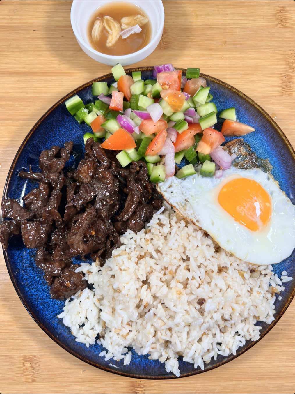 Tapsilog for almusal!🍳🌞 Tapa ingredients: 500g beef, thinly sliced 1/4 cup soy sauce 8 pcs cloves garlic, chopped 3 tbsp lemon/ calamansi juice 1/4 cup brown sugar Ground black pepper Serve with garlic fried rice, fried egg, and cucumber, tomato, onion salad. #filipinobreakfast #almusalidea #tapsilog #silog #pinoyfoodie #FoodTok #fyp #foryou #foryoupage 