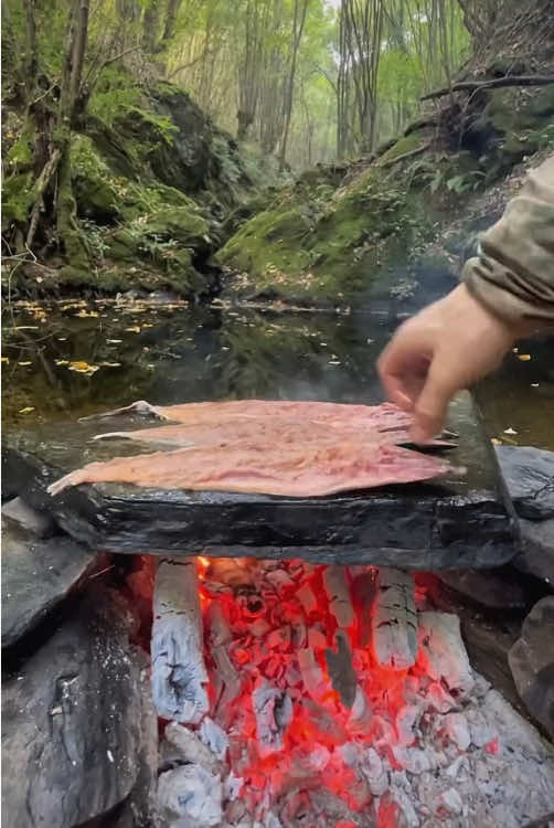 Sea bass grilled on hot stones in nature 🐟💦🪵🔥 #outdoorcooking #cookingasmr #Recipe #leon #cookingnature #foodtiktok #camping #seabass 