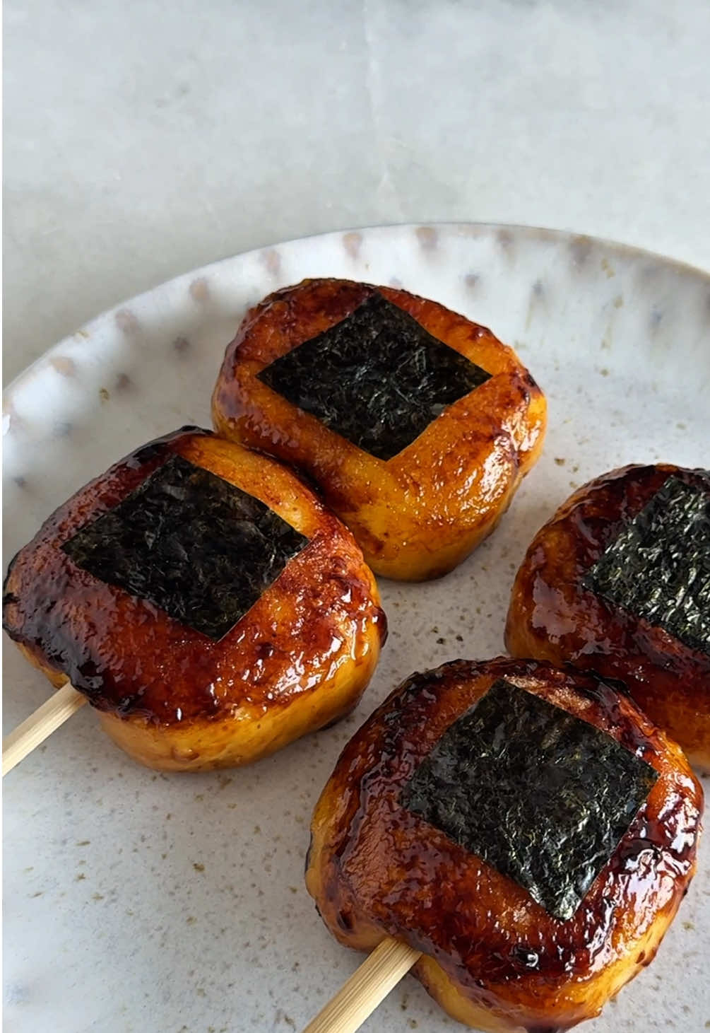 Imo mochi 🥔 de Demon Slayer  Spécialité culinaire d’Hokkaido 🇯🇵  Pour environ 8 mochis : - 450g de pomme de terre  - 3cs bombées de farine de riz gluant - Sel, poivre - 30g de beurre  - Mozzarella râpée (optionnel) La sauce : - 2cs de sauce soja  - 1cs de sirop d’érable  - 1cs de mirin  - 2cs d’eau  - 1cc de fécule de maïs  Étapes : 1. Pelez et coupez les pomme de terre en cubes. Faites les cuire dans une casserole d’eau avec 1 pincée de sel  2. Une fois cuites, écrasez les pomme de terre avec le beurre, assaisonnez de sel et de poivre  3. Ajoutez la farine de riz gluant et pétrissez jusqu’à obtenir une boule de pâte lisse et homogène (rajoutez de la farine si ça colle trop) 4. Formez un boudin et découpez le en 8 parts égales 5. Formez des boules, puis un creux. Ajoutez un peu de mozzarella râpée, refermez bien la boule de pâte et formez un carré  6. Dans une poêle avec un filet d’huile, faites griller de chaque côté vos Imo mochi. Retirez les de la poêle pour faire cuire la sauce  7. Dans un récipient, mélangez tous les ingrédients de la sauce et ajoutez les dans la poêle. Remuez rapidement à feu doux jusqu’à ce que la sauce soit bien nappante  8. Nappez vos Imo mochi de cette sauce à l’aide d’un pinceau et piquez les à l’aide d’un pic à brochette si souhaité À déguster tiède ✨ #imomochi #mochi #hokkaido #demonslayer #popculture #manga #Anime #japanesefood #recettefacile 