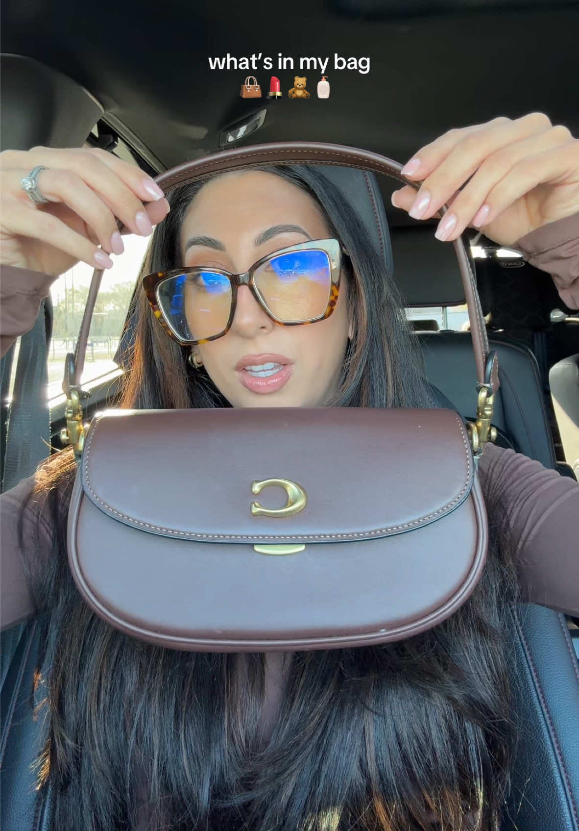 what’s in my bag 👜💄🧸🧴 @Coach emmy saddle bag 23 in maple  • @touchland hello kitty sanitizer  • @MakeUpForEverUSA @makeupforever lip liner (wherever walnut) • @SACHEU Beauty US lip stain  • @Fenty Beauty gloss (sweet mouth) • @Josie Maran body butter (vanilla vibezzz)  • @Kylie Cosmetics @Kylie Jenner cosmic perfume  • @Olive & June cuticle oil  #whatsinmypurse #whatsinmybag #coachbag #coachemmysaddlebag #emmysaddlebag23 