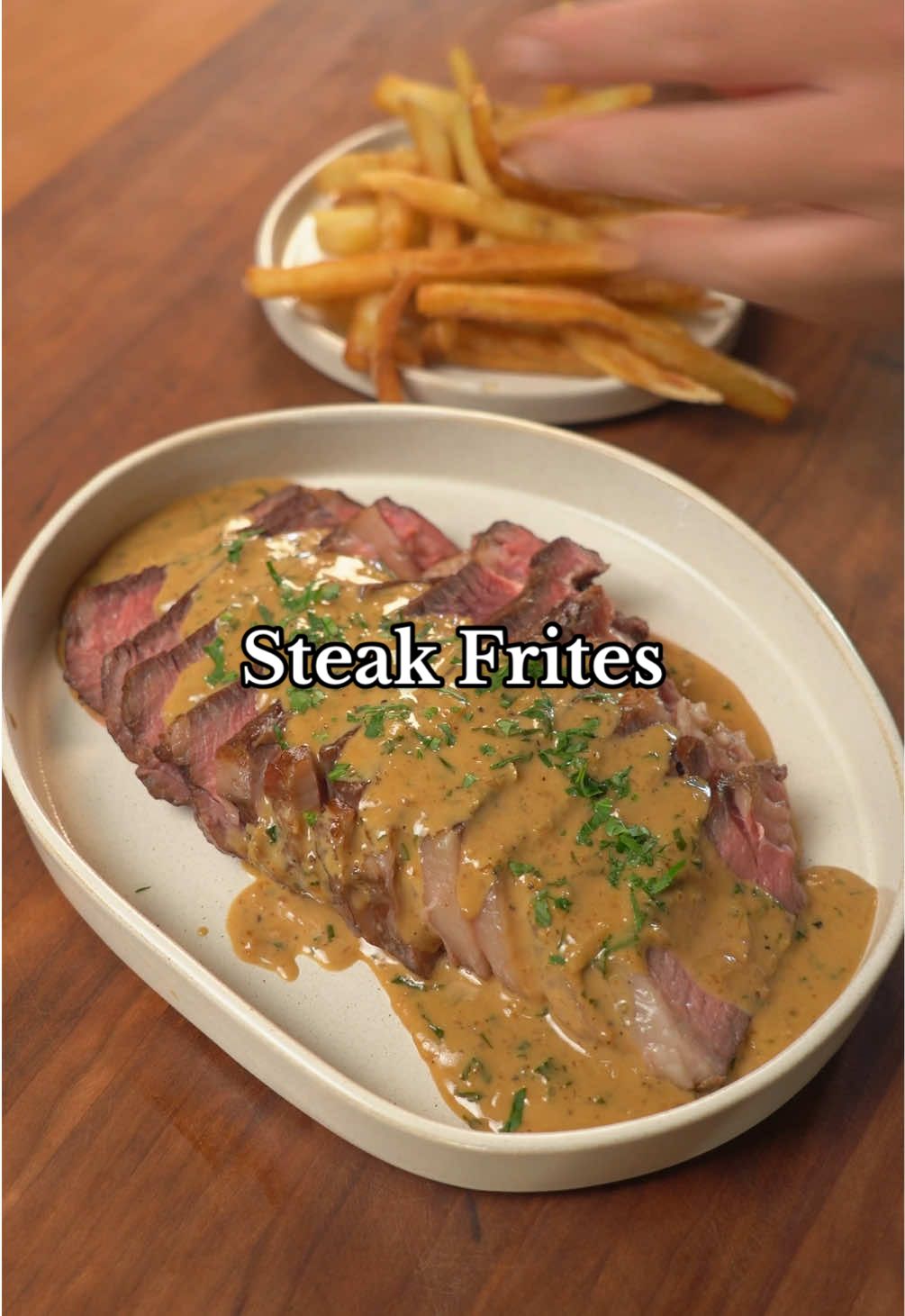Steak Frites(recipe inspo from @cabagges ) Ingredients * 1 ribeye steak(1.5-2 inches thick)] * Salt * 2 tbsp neutral oil or tallow * 1 shallot(minced) * 3 cloves garlic(minced) * 2 tsp freshly cracked black pepper * 1/4 cup mirin * 2 tbsp sake * 1 tbsp red miso * 1 tsp beef bouillon paste * 1/2 cup heavy cream * 1 tsp mustard * 1 tsp lemon juice * 1 tbsp unsalted butter * 1/4 cup parsley(chopped) * Oil for frying * Frozen fries Instructions 1. Get a well-marbled steak thats at least 1.5 inches thick and season all sides with salt. Let dry brine in the fridge uncovered overnight. 2. I like reverse searing because it gives consistent results and less of a grey band when searing the steak. Place steak in an oven set at 215F for 45 minutes to an hour until the internal reaches 10 degrees less than your desired doneness. I took mine out at around 115F for medium rare. 3. Let the steak rest for 5 minutes while you heat a heavy bottom pan(cast iron, carbon steel, stainless steel) for 2 minutes on medium high heat. Add in neutral oil/tallow and once shimmering, pat the steak dry with a paper towel and quickly sear the steak for no more than a minute on each side. Let the steak rest while you make the sauce and fries. 4. In the same pan, sauté shallots, garlic, and black pepper on medium heat until translucent(2-3 min). 5. Deglaze with mirin and sake and once the alcohol has evaporated and there’s very little liquid left, add the red miso and beef bouillon paste. 6. Once incorporated, pour heavy cream and bring to a simmer until slightly thickened. 7. Add mustard and lemon juice then turn off the heat and swirl in cold butter. 8. Finish with parsley and season to taste with salt. 9. Fry fries according to package instructions and season with salt. 10. Slice the steak and serve it with the sauce and fries. #tablefortwo #tablefor2 #steak #steakfrites #fries #reversesear #datenight #datenighrecipe #datenighrecipes #Recipe #cooking #food #recipevideo #cookingvideo #foodvideo #EasyRecipe #EasyRecipes #recipetutorial #cookingtutorial #foodtutorial 