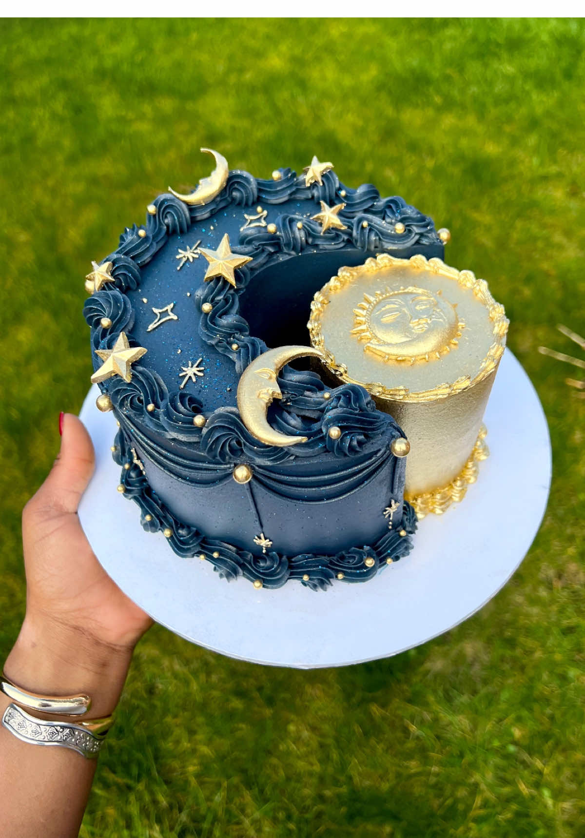 Decorating the viral sun and moon cake 🌙🌞  I created this design last year April and I am obsessed with all the variations and creativity I’ve seen in people’s recreations, the baking community never ceases to amaze me! No hate to those who haven’t tagged me, you may not have known I created this, so putting this video out there to refresh everyone’s memory and to say keep being creative! I absolutely love to see it 🥹✨ . . . #kutiwacakes #cake #caketok #caketiktok #cakedecorating #cakevideo #manchestercakes #creativecakes #celestialcake #sunandmoon #sunandmooncake #moonandsun #moonandsuncake #navyandgold #piping #pipingvideo  #satisfying #viral #fyp #droplines #birthdaycake #cakeart #buttercream #fondant #cakeideas #cakeinspo #cakeinspiration #cakedesign #tagme #BookTok 