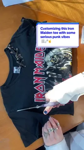 Customizing this Iron Maiden tee with some serious punk vibes 🎸💥 Watch me take this classic Iron Maiden tee and give it a bold punk twist for a client! Using safety pins, spray paint, and a splash of pink paint, we're creating a one-of-a-kind design with some serious edge. Stay tuned to see the transformation 🔥  #DIY #PunkStyle #IronMaiden #CustomTee #SafetyPins #SprayPaintArt #PunkVibes #UpcycledFashion #DIYDesign #AltFashion #upcycledfashionbrand #fashiondesigner #diyproject #fashiondiy #Upcycling #altgirls #rockgirl #metalgirl 