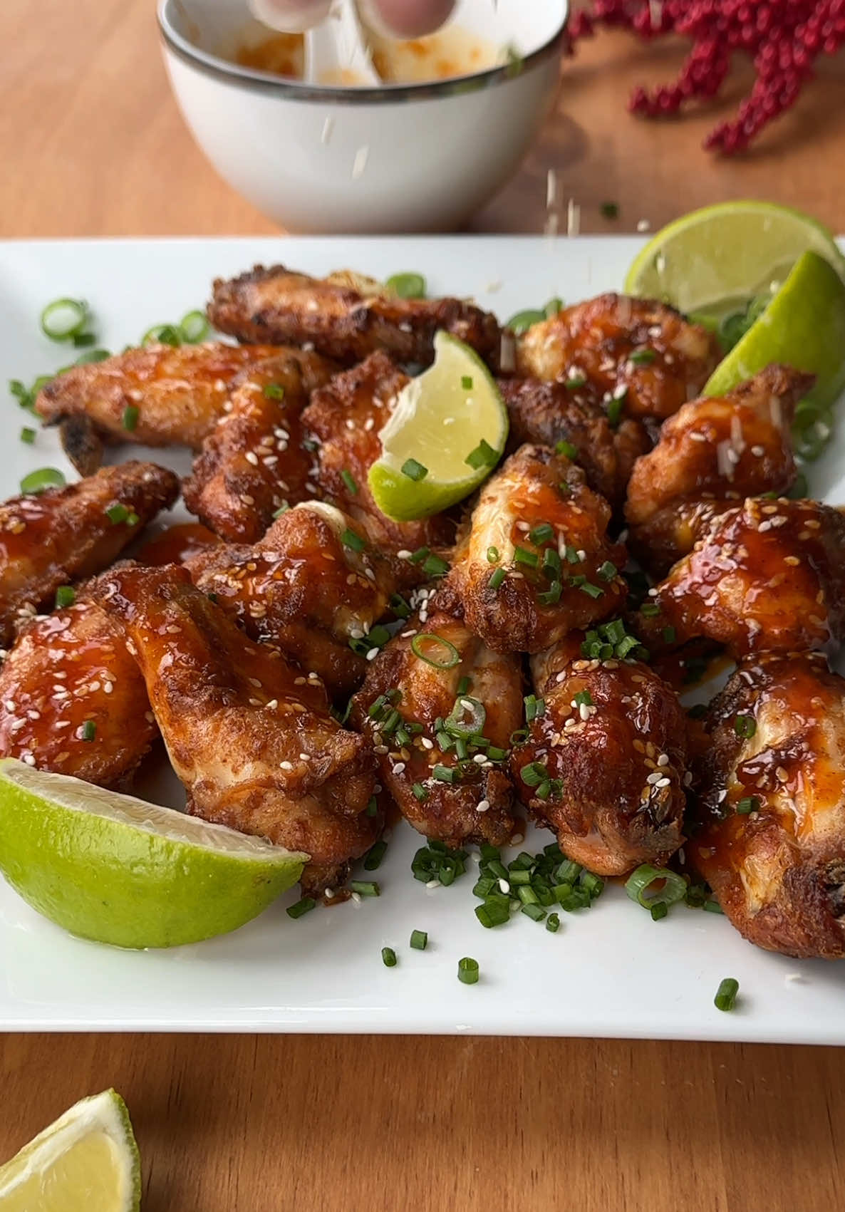 Crispy Oven-Baked Chicken Wings with Spicy Honey Sesame Glaze Ingredients For the Chicken Wings:  • 600g chicken wings  • 1 tbsp white vinegar  • ½ tsp smoked paprika  • 1 tsp garlic powder  • ½ tsp cayenne pepper  • ¼ - ½ tsp black pepper  • ¼ tsp white pepper  • ¼ tsp celery salt  • ½ tsp salt  • 1 tbsp baking powder  • 1½ tbsp cornstarch  • 3 tbsp beef tallow For the Honey Sesame Sriracha Sauce:  • 4 tbsp butter  • 1½ tbsp sriracha  • 1 tbsp honey  • ¼ tsp smoked paprika  • ¼ tsp garlic salt  • 1 tsp sesame seeds  • 1 tsp sesame oil  • ½ lime, juiced For Garnishing:  • Extra lime juice  • Sesame seeds  • Chopped green onion Instructions:- Step 1: Prepare the Chicken Wings  1. Pat dry the chicken wings with a paper towel to remove excess moisture—this ensures crispiness.  2. In a large bowl, combine the wings with white vinegar, smoked paprika, garlic powder, cayenne, white pepper, black pepper, celery salt, salt, baking powder, cornstarch, and beef tallow. Mix well to coat evenly.  3. (Optional) Let the wings marinate in the fridge for 1 hour for deeper flavor. Step 2: Bake the Wings  4. Preheat your oven to 420°F (215°C).  5. Place the wings on a wire rack set over a baking tray to allow air circulation. Sprinkle extra salt if desired.  6. Bake for 25-30 minutes, then flip and bake for another 25-30 minutes.  7. If needed, flip again and bake for an extra 5-10 minutes until crispy and golden brown. Step 3: Prepare the Sauce  8. In a small saucepan over medium heat, combine butter, sriracha, honey, smoked paprika, garlic salt, sesame seeds, and sesame oil.  9. Simmer for 1 minute, stirring continuously. Do not boil.  10. If the sauce separates, blend with an immersion blender until smooth. Step 4: Coat the Wings & Serve  11. Once the wings are crispy, toss them in the sauce or drizzle the sauce lightly to maintain crispiness.  12. Garnish with fresh lime juice, chopped green onions, and a sprinkle of sesame seeds.  13. Serve immediately and enjoy! #CrispyChickenWings #Foo#CrispyChickenWingsSpicyWings #Tasty
