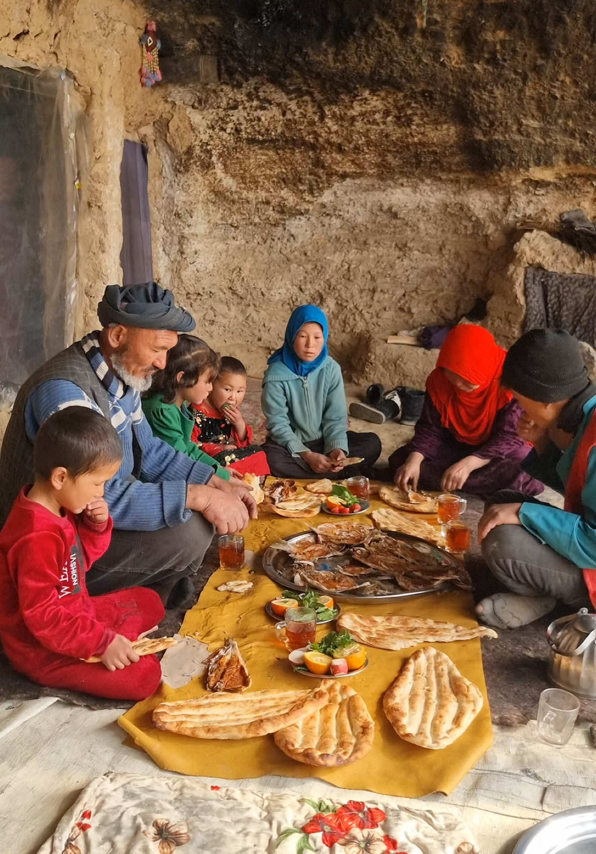 A Warm Family Gathering in Bamyan’s Historic Caves: Enjoying Fish and Traditional Bread During Winter In the heart of Bamyan, Afghanistan, a large family comes together inside an ancient cave to share a meal of freshly prepared fish and traditional bread. Despite the harsh winter conditions outside, the warmth of family bonds and cultural traditions create a cozy and memorable evening. #Bamyan #Afghanistan #FamilyDinner #CaveLiving #WinterMeals #TraditionalBread #CulturalHeritage