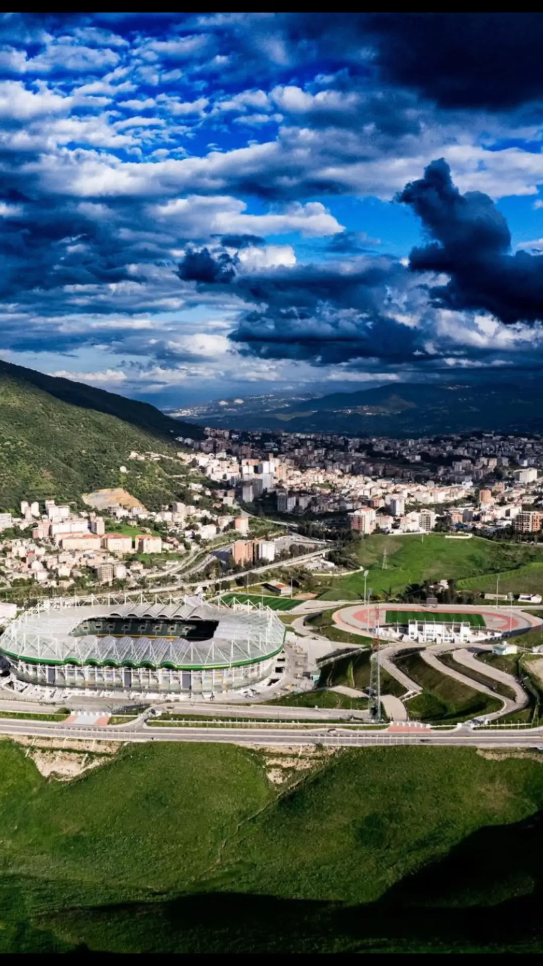 صورة تشمل الملعب الجديد لمدينة تيزي وزو ومنها جبال مقابلة ومدينة وغيوم تزين كل ما بحول المدينة #jsk #jskabylie💛💚 #tiziouzou #kabyle #kabyle_girl #kabylie #dz #paris 