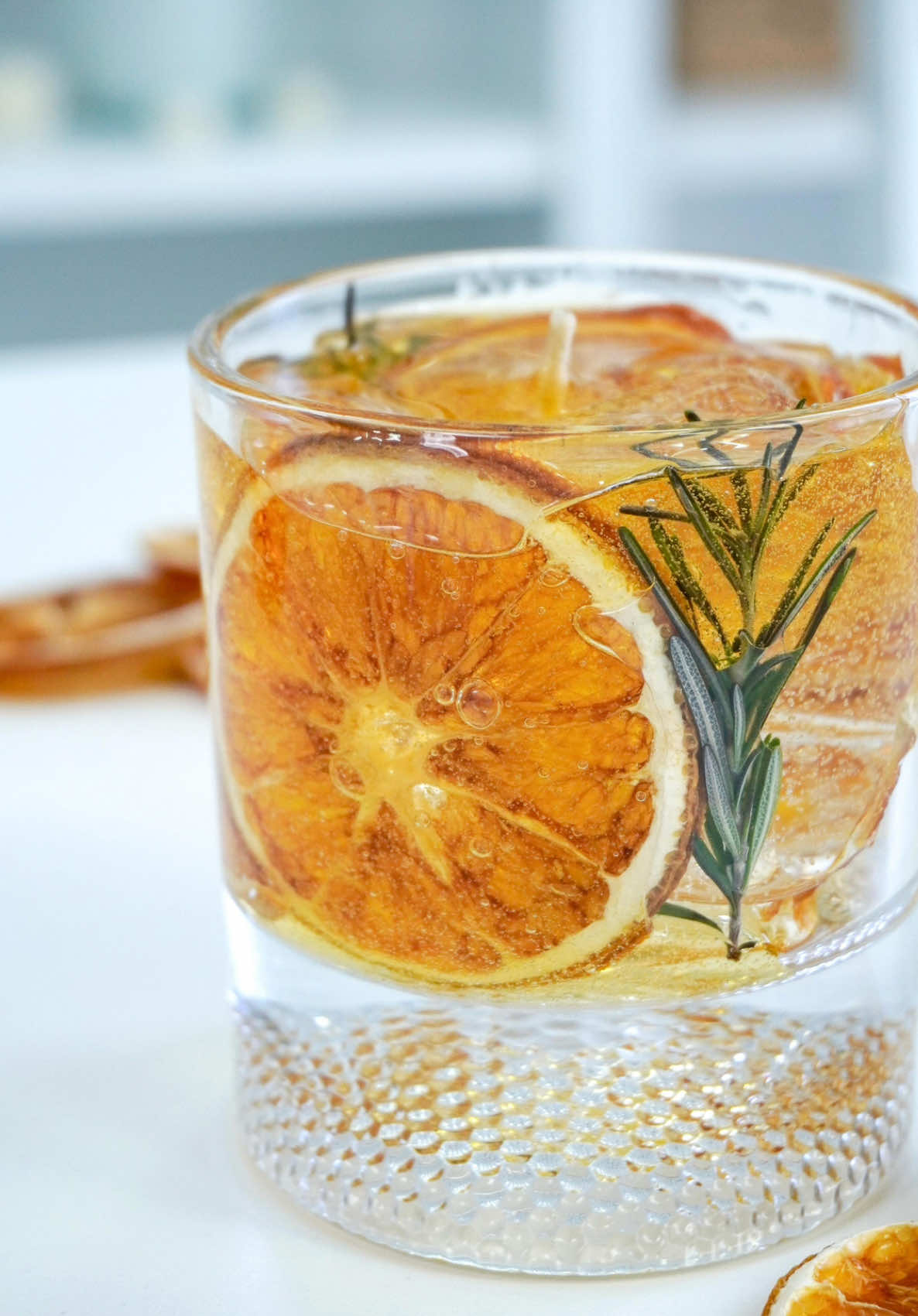 ✨30 dias, 30 velas – Dia 13✨ Hoje a vela é puro charme pra decoração! Inspirada em um drink refrescante🍹essa criação foi feita com parafina gel, laranja desidratada 🍊 e raminho de alecrim — simples nos elementos, mas cheia de presença. Diferente das outras, essa vela não tem aroma. Ela é uma peça decorativa, perfeita pra bandejas, aparadores ou aquele cantinho com cara de barzinho em casa. Já salva esse post se você ama velas com cara de objeto de design! E claro… continua acompanhando, porque o desafio ainda tem muita vela incrível vindo por aí! 🔥 . . . #30Dias30Velas #velasaromaticas #cursodevelas #velas #velaartesanal #velasaromáticas #velasartesanais #velaaromatica #candle #DIY #candlemaking #artesanato #artesã #feitoamao #veladrink #drinkcandle #drinks 