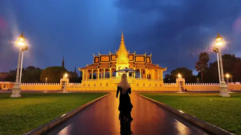 On a rainy night with lightning and thunder, I walk before the Grand Palace in Phnom Penh, the wet stone path reflecting my figure. Lightning splits the sky, illuminating my resolute gaze, my skirt swaying in the wind as I resonate with the heavens and earth. #RainyNightAdventure #MyPerspective #PhnomPenhGrandPalace