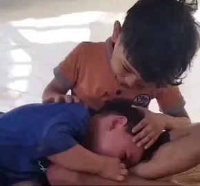 مشهد مبكي من غزة، طفلٌ صغيرٌ يواسي أخاه الأصغر، بعد أن فقدا والدتهما.. آهٍ يا غزة آه.