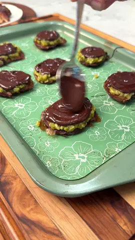 Can't find pistachio cream of shredded phyllo? No problem....these DUBAI CHOCOLATE DATE BITES are made with 3 ingredient homemade pistachio cream and rice crispies. Makes 15 Ingredients: 1 ½ cups shelled pistachio ½ cup powdered sugar ½ tsp salt ⅓ cup avocado oil 1 cup rice crispy cereal 15 pitted medjool dates 1 cup dark chocolate chips Flaky Sea salt -Add pistachio, sugar and salt to a food processor and blend on high. Stream in the avocado oil and continue to blend until smooth and creamy -Add rice crispy cereal and pistachio cream to bowl and mix well. -Open the dates and place them skin side down onto a parchment lined tray. Place a piece of wax paper or plastic wrap on-top of the dates and use the bottom of glass to flatten the dates.  -Spoon about a 1½ tbsp of the rice crispy mixture on to each date and press flat. -Add chocolate chips to a microwave safe bowl. Microwave for 30 second intervals, stirring in between, until the chocolate is fully melted.  -Spoon about a tbsp of melted chocolate over each date. -Top each date with a date of flaky sea salt. -Refrigerate for an hour and enjoy! *store leftovers in the refrigerator for up to 7 days. #dubaichocolate #dubaichocolatedatebarks 