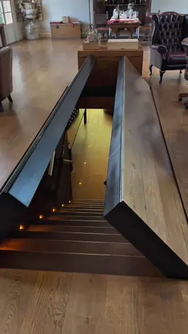 A stunning hidden staircase is revealed as the wooden floor opens up in a sleek, arrow-shaped motion. This secret entrance leads to an underground space, showcasing brilliant interior design and smart home innovation.  #SecretStairs #SmartHomeDesign #LuxuryInteriors #HiddenRoom #HomeInspiration #ArchitecturalDesign #IngeniousDesign #ModernLiving #interiorgoals 