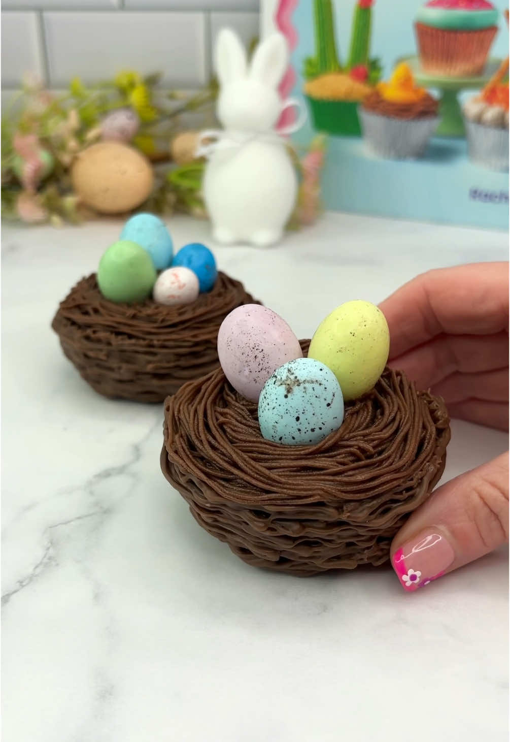 Chocolate cupcake nests 🍫🧁🪺 Turning my edible wrappers into nests for Easter 🐣🐰🧁 😋🩷🍫  Chocolate cupcakes, hidden inside a chocolate nest, topped with chocolate buttercream and speckled eggs 🩵💗 🍫 I used chocolate candy melts to make the nest. 🐣 Swirl the melted chocolate over a cupcake liner.  🐰 Let it set between each layer.   🍫 Remove the cupcake liner. 🧁 Add a chocolate cupcake to the centre. 🐥 Use tip 233 to add some chocolate buttercream and sit your eggs on top  #cupcake #cakedecorating #easterbaking #chocolate #cakedbyrach #cutefood #minicake #cupcakesforanyoccasion   