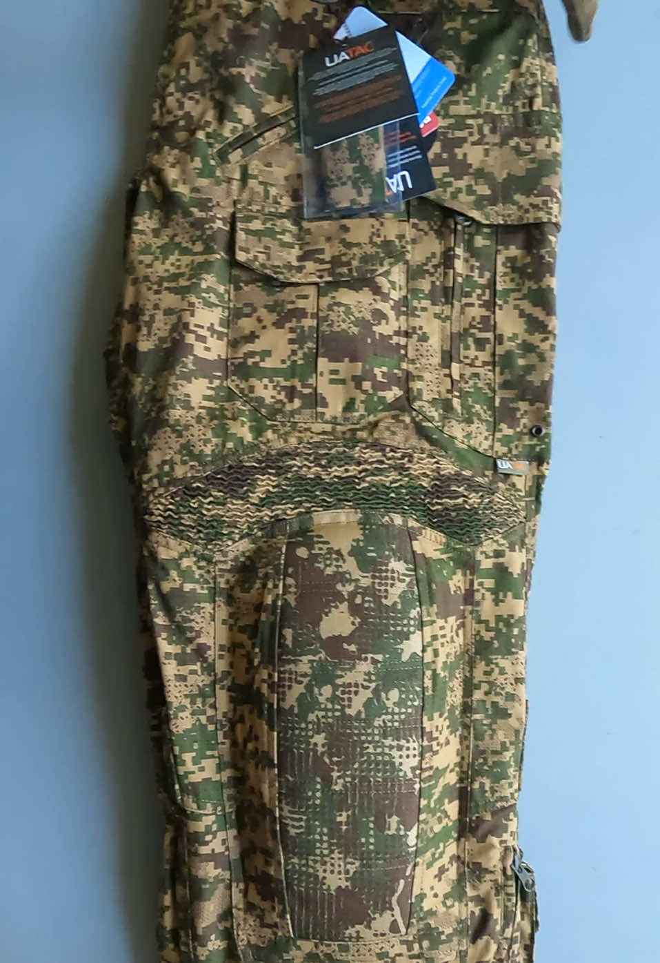 Combat pants UATAC Gen 5.4 with knee pads | Khyzhak Pixel The UATAC Gen 5.4 Khyzhak Pixel assault pants with knee pads have the following features: Fabric: 65% cotton, 35% polyester. The fabric is RIPSTOP, which means it has reinforced strength and wear resistance. It is also waterproof. Thread: The pants are sewn with a German reinforced thread. Buttons: There are buttons on the cargo pockets and at the waist. Ventilation Flaps: There are additional ventilation flaps on the zipper. These are reinforced with mesh. Zipper: There is a zipper on the cargo pocket for convenient use while sitting. Tourniquet Pocket: The pants feature a new version of the tourniquet pocket. Stretch Panels: The pants have increased stretch panels for better comfort during active use. Knee Pads: The pants come with insertable knee pads that are adjustable in height. The new generation knee pads are more convenient to use and are externally protected by reinforced 1000D Cordura. Zippers: All zippers are from YKK (Japan) and are very reliable and high quality! Waist Adjustment System: The pants have a convenient waist adjustment system. Cargo Pockets: Each cargo pocket contains a stabilizer for a water bottle/magazine. Equipment Holder: There is a special holder for a flashlight or other equipment, which provides easy access to neighboring pockets. Knee Height Adjuster: There is a practical knee height adjuster located in the front pocket. It is designed for use with interchangeable knee pads. Seating Area: The pants feature a double-layer seating area. These features make the UATAC Gen 5.4 Khyzhak Pixel assault pants a reliable and comfortable choice for tactical use #combatpantsformen   #combatpantsacquisition   #combatpants8pucket   #combatpantsinlagos   #combatpantssport   #uatactacticalpantsprice   #uatacshop   #uatactacticaljacketprice   #тактическиештаны   #штанизнаколінниками   #тактичнийодяг   #uatactacticalpants   #tacticalpantsmen   #формавійськова   #pantsmulicam   #штанимультикам   #original   #uatac   #uatacukraine   #uatacuniform   #uatactech   #uatacpants   #pants   #pantsformen   #pantsmulticam   #pantsmulticargo   #штани   #штаниукраїна   #штанижіночі   #штанинарезинці   #штанивеликихрозмірівукраїна   #штаниолива   #pantscargo   #штаникойот   #тактичніштани   #pantsolive   #штанипіксель   #штанимм14   #patntsformen   #pantsmulticamе   #формамультикам   #UATACGen56 #CombatPants #TacticalGear #BlackTactical #KneePadPants #MilitaryStyle #GearUp #TacticalLife #RuggedWear #OutdoorReady #BattleTested #DurableDesign #TacticalFashion #AdventureGear #SurvivalStyle #ActiveDuty #ToughThreads
