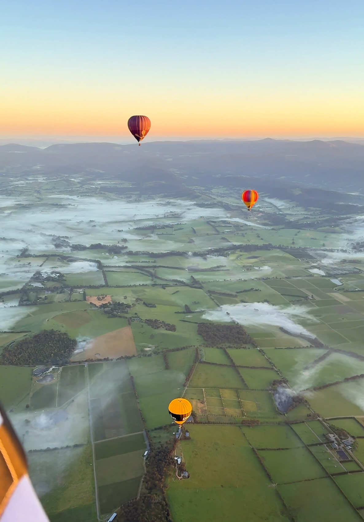 Scenic rides never looked so good 🎈 An easy, one-hour drive from Narrm (@Visit Melbourne) will deliver you to the lush @Visit Yarra Valley. *Literally* rise and shine with @Global Ballooning Australia’s sunrise hot air balloon ride, before making your way to the Puffing Billy Railway to cruise through the Dandenong Ranges with the wind in your hair 🚂 🎥 : IG/globalballooningaustralia 📍: Global Ballooning Australia and Puffing Billy Railway, Yarra Valley and the Dandenong Ranges, #Victoria (@visitmelbourne) #SeeAustralia #ComeAndSayGday #Melbourne #YarraValleyDandeongRanges ID: A series of videos that show people riding in a hot air balloon over rolling green hills, then riding a vintage steam train through bushland with their legs dangling.