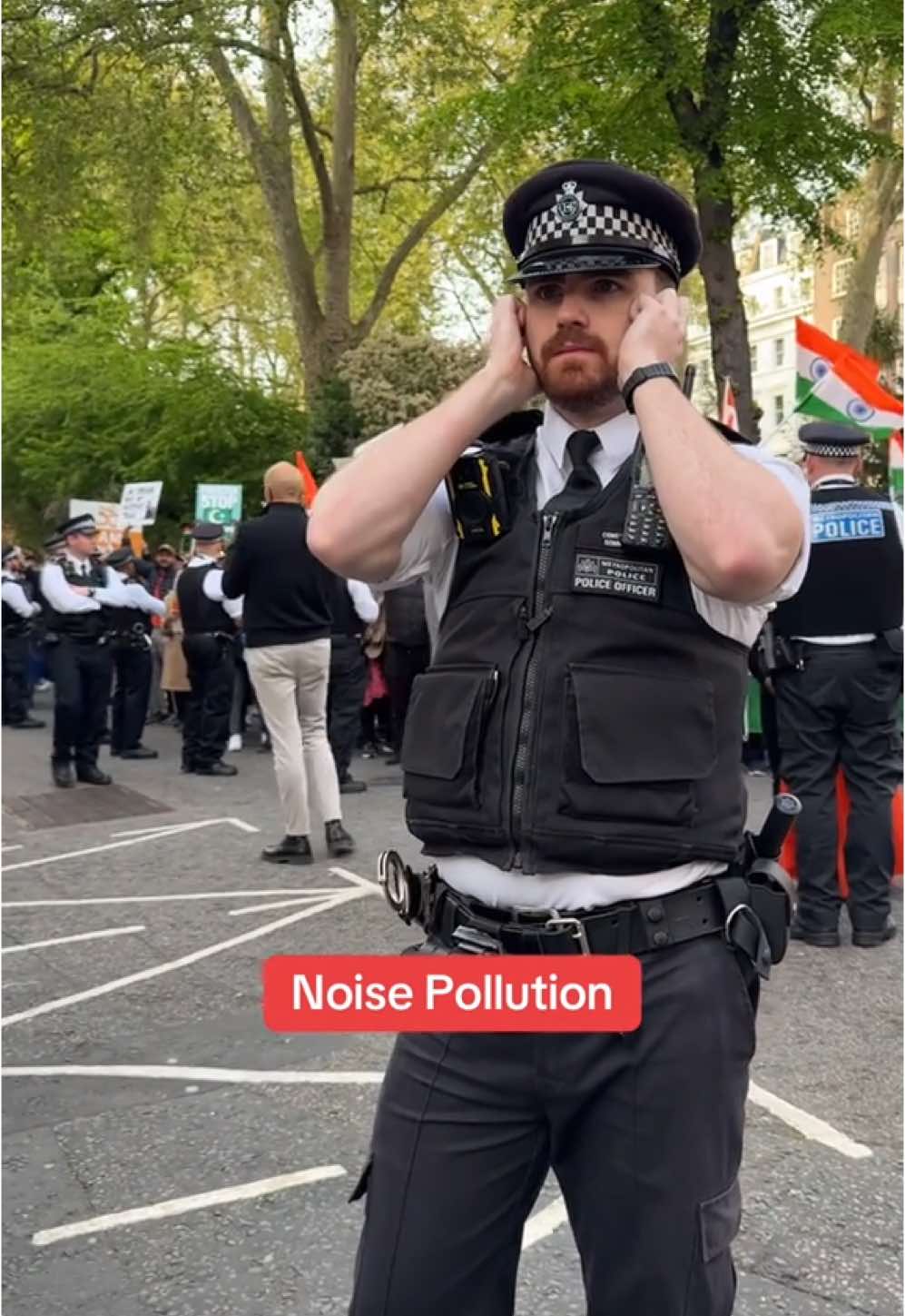 Met police officer plugs his ears amidst the chaos, Pakistani and Indian protesters come face to face,  tension and shouting erupt.