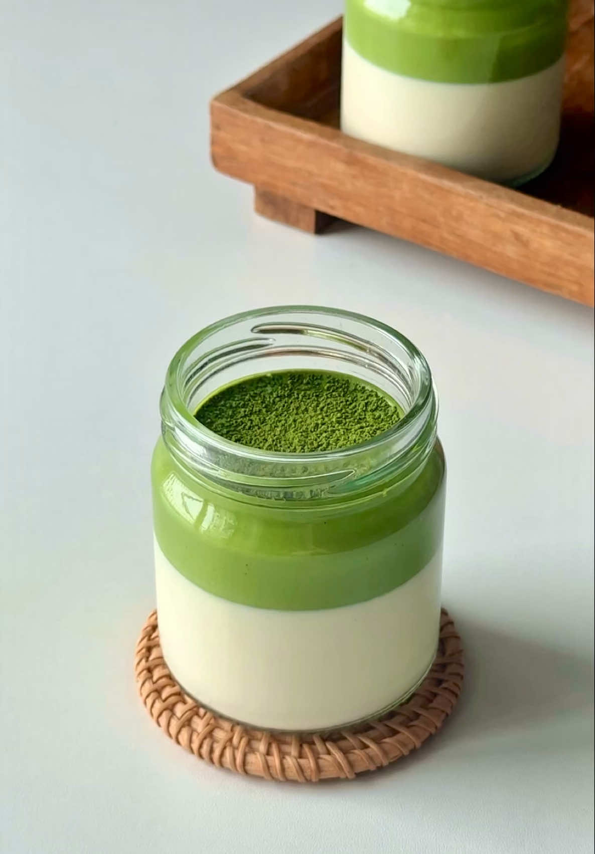 Easy Matcha Panna Cotta 🍵🥛 no stove needed, only microwave. And I made these just under 4 hours! I could have refrigerate longer to let the matcha top set, but I couldn’t resist myself trying it out 🌝🤍  2 pcs gelatine sheets 150ml milk of choice 150ml heavy cream 40g sugar 1tsp vanilla extract (i forgot to put it in 😂) 8g matcha 1. Soak gelatine sheets piece by piece in cold water and set aside for 5-10 minutes. (Avoid soaking all sheets at once, it will stick together and some parts wont absorb enough water!) 2. Heat milk in microwave for 1 minute or until hot to touch. Add sugar and stir until dissolved. 3. Add soaked gelatine and stir until dissolved, followed by heavy cream, vanilla extract, and stir until combined. 4. Pour in glass jar or ramekins and refrigerate until set. You can also put them in freezer for 30 minutes to speed them up. 5. Sift matcha powder and add 1/3 of cream mixture, whisk until smooth. Add the remaining cream and mix until combined. 6. Pour the matcha cream on top of the panna cotta. Refrigerate until set. Dust with some more matcha powder and enjoy 🍵❤️ #matcha #Recipe #matchalover #dessert #มัทฉะ #pannacotta #matchapannacotta #easy #EasyRecipe #easydessert #microwave 