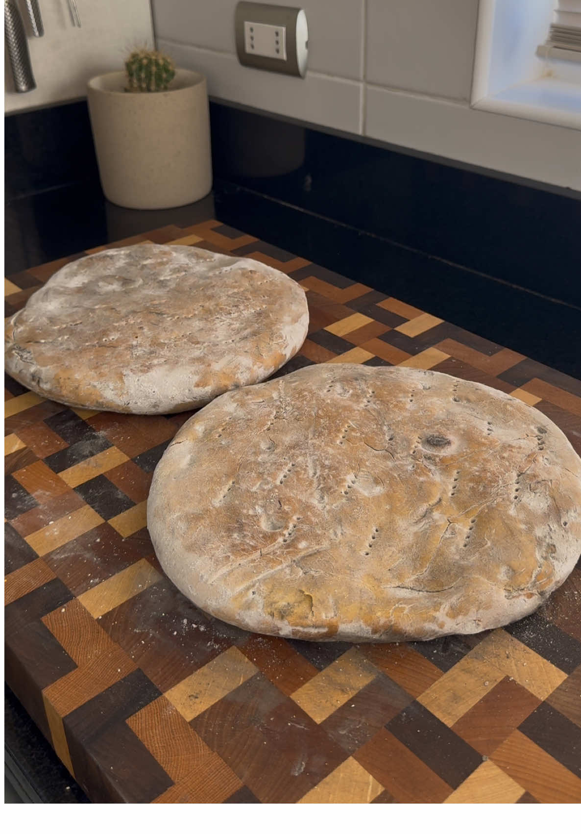 Me gusta cuando me dicen que no queda pan porque me motivo a preparar un pancito casero y esta vez les traigo una #tortilladerescoldo con ceniza de roble, quedaron espectaculares con pebre, un clásico del centro y sur de Chile 🇨🇱 y también otros lugares de Sudamérica y el mundo 😉 Receta del mes de la cocina Chilena  Tortillas de rescoldo (2 unidades)  1 kilo de harina sin polvos 2 a 3 cucharadas de manteca 500 ml agua tibia 20 g sal 20 g bicarbonato  1 saco de 20 kilos de leña (ojalá roble)  Primero preparar la ceniza, para eso quemamos leños de roble 🪵 por 2 horas aproximadamente para generar una buena cantidad de cenizas. Mientras, se prepara la tortilla uniendo todos los ingredientes y amasando muy bien por unos 10 minutos app. Deja reposar la masa tapada unos 30 min y luego divídela en 2 partes iguales. Estira y pincha con un tenedor. Ya con suficientes cenizas, espárcela hacia los costados dejando el centro libre, se calentará la base de la parrilla si es loza, coloca ahí la primera tortilla y tapa con cenizas. Cocina por 10 min y luego da vuelta y vuelve a tapar con cenizas y cocina por 10 min más. Luego hacer el mismo procedimiento con la segunda tortilla. No olvides hacer un fuego paralelo  y mantener con brasas las cenizas para generar el calor suficiente para cocinar la tortilla. Una vez lista, saca la tortilla de las cenizas con unas tenazas y deja enfriar unos minutos antes de quitar el exceso de cenizas con una escobilla o paño. Sirve la tortilla sola calentita, con pebre, mantequilla, palta o con lo que más prefieras, seguro la vas disfrutar 👋😄