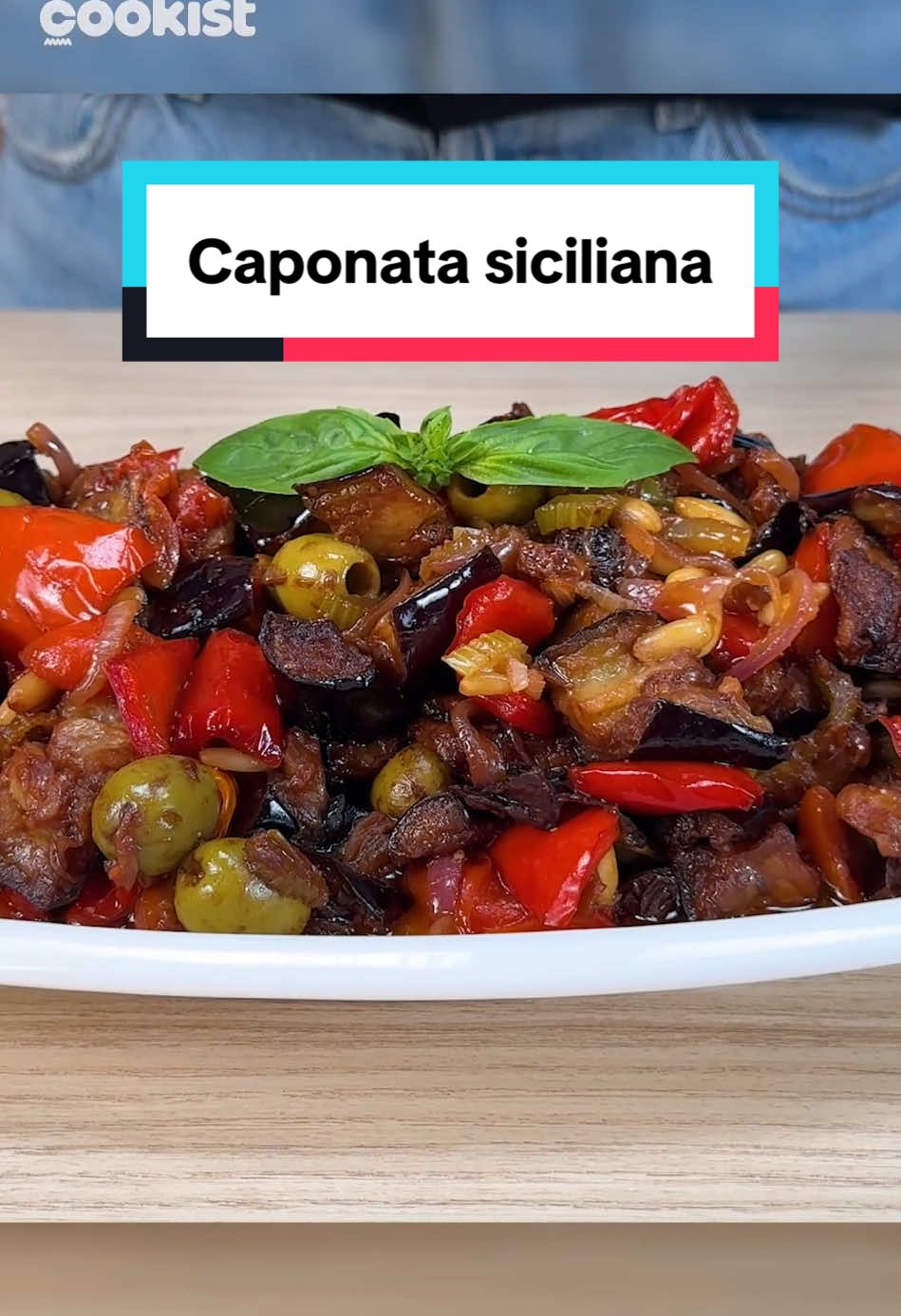 🍆CAPONATA SICILIANA! Non è solo un contorno: è un’esplosione di sapori agrodolci che racconta la Sicilia in ogni boccone 😍 La nostra Julia ci mostra come prepararla: 👉INGREDIENTI 3 melanzane grandi  2 peperoni rossi  Pomodorini q.b   1 cucchiaio di capperi 50g di uvetta (idratata in acqua o marsala)  40g di pinoli  70g di olive verdi denocciolate  2 coste di sedano  2 cucchiai di aceto  2 cucchiai di zucchero  1 cucchiaio di cacao amaro 👉PREPARAZIONE 1. Taglia le melanzane a cubetti e friggi. Idem con il peperone. 2. Taglia il sedano e sbollentalo in acqua per 5 minuti. 3. In un padella fai rosolare la cipolla e i pomodorini, poi aggiungi il sedato sbollentato, i pinoli, l’uva passa e le olive verdi. 4. Aggiungi melanzane e peperoni fritti. 5. Aggiungi poi zucchero e aceto per il tocco agrodolce. 6. Tocco in più un pizzico di cioccolato fondente.   #cookist #caponatasiciliana #caponata 