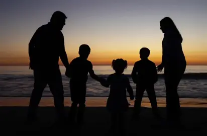 As the sun sinks low in the sky, painting everything in warm shades of orange, a family of five stands together at the water's edge, their silhouettes framed against the glowing sea. The parents hold hands with their kids, creating an image of unity. The oldest son reaching out gently to his baby sister, her tiny hand rises to meet his, and for a moment, they are sharing a sweet bond. The soft sand beneath their feet holds the marks of their playful movements, and the fading sunlight frames them perfectly. In this quiet moment, without words, their small actions speak volumes about love, connection, and the simple joy of being a family, as day turns to night. #silhuohette #photography #photographer #sunset #sanclemente #family #familyphotos #familyphotographer 