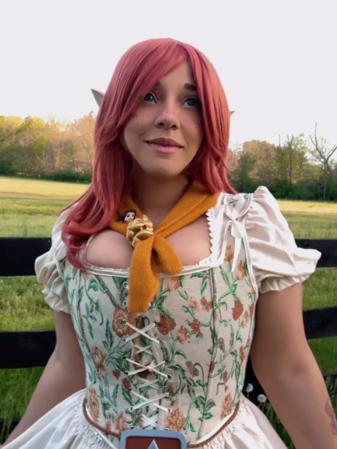 …and something in me softened like I’d been there all along. I found myself watching the sky like I was waiting for something strange… and before I knew it, I was carrying the weight of the ranch in my heart. I’ve always loved Majora’s Mask! it’s haunting, beautiful, and Cremia’s quiet strength really stuck with me. Her bond with Romani, her secret heartbreak, and the mystery of the ranch during the moon’s final days of descent feels like a soft sci-fi dream wrapped in melancholy. This game gave me an experience I won’t forget. So many stories that were told, with adventure and hope. Truly my favorite. Especially Romani Alien Quest, she’s an iconic and cool little girl!  Channeling my version of Cremia this past weekend, I visited a sweet dairy farm, met some adorable animals and even spotted a lone horse while driving…like Epona watching over everything. It felt like stepping into the game itself. Contacts are Sweety Berry Cyan from @UNIQSO  Gold Scarf Bowser Pendant & Triforce Belt buckle created by @Outtaline cosplay  Corset gifted by an amazing soul Elf Ears gifted via ThroneList by Archer  Reddish Orange Wig gifted anonymously via Throne List  #fyp #foryou #biracial #cosplay #makeup #zelda #zeldamajorasmask #cremia #cremiacosplay #romaniranch #dairyfarm 