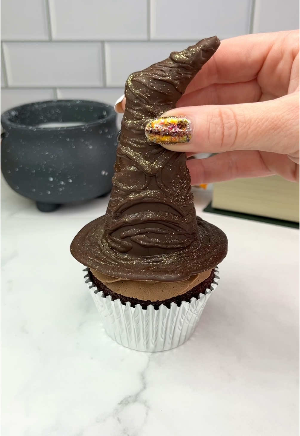 It’s… International Harry Potter Day 🦉❤️💛 The sorting hat 🧙🏼‍♀️🪄 Lift them up to see what house you’re in.  🪄♥️💙💛💚 How to turn an🍦cone into a sorting hat.  🪄 Cut the point off an ice cream cone, stick it the opposite way with some melted chocolate.  🪄 Dip the end into the melted chocolate. 🪄 Sit it onto parchment paper and pour over melted chocolate. Use a toothpick to help guide the chocolate, making a brim around the bottom.  🪄 I used a thin decorating brush and melted chocolate to add some texture to the hat.  🪄 Add a colourful swirl of buttercream to your cupcakes. 🪄 Fill the cones with coloured candy.  🪄 Sit the cupcake onto the hat and carefully flip them over.  #cupcake #harrypotter #thesortinghat #easyideas  #cakedbyrach #chocolate #cutefood #cakeart #cupcakesofinstagram #cupcakesforanyoccasion 