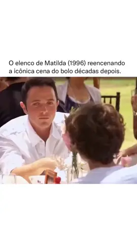 Em 2018, o elenco do clássico Matilda (1996) surpreendeu os fãs ao se reunir para reencenar uma das cenas mais emblemáticas do filme: o inesquecível desafio do bolo de chocolate. No filme original, a cena acontece quando Bruce Bogtrotter, interpretado por Jimmy Karz, é forçado pela diretora cruel Agatha Trunchbull (Pam Ferris) a comer um enorme bolo de chocolate inteiro na frente de toda a escola. O momento, que mistura tensão, humor e superação, se tornou um dos mais lembrados da história do cinema infantil. Décadas depois, para celebrar o legado de Matilda, Jimmy Karz e outros membros do elenco original, incluindo Mara Wilson (Matilda), voltaram a interpretar essa sequência em um reencontro especial. A iniciativa fez parte de um projeto nostálgico promovido por eventos de cultura pop e mídias especializadas, reacendendo a memória afetiva de toda uma geração que cresceu assistindo ao filme. Jimmy Karz, que tinha apenas 12 anos quando filmou a cena original, hoje é médico, mas aceitou o convite para recriar o momento com bom humor. A nova versão foi feita em clima de celebração e diversão, sem a tensão assustadora da cena original, e rapidamente viralizou nas redes sociais, mostrando a força duradoura de Matilda como um dos filmes mais queridos dos anos 1990. #filmesclassicos #matilda #anos90 