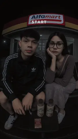 prompt:Create an image ultra realistis, foto realistis di ambil dengan kamera fish eye ukuran foto 4:6  Saya memakai jaket seperti yang di gambar  memakai celana pendek Chino hitam  Memakai sepatu Adidas samba ORI  Cewek memakai seperti yang di foto  Kami berdua duduk dan bersandar (full body  dari atas kepala hingga kaki) di kursi besi di atas meja ada 2 minuman kopi dan sebungkus rokok Filter kami saling berhadapan depan Alfamart suasana malam itu sangat sepi terlebih baru selesai hujan. Tolong buatkan serealistis mungkin.  #chatgpt #trend  #Al #capcut_edit 