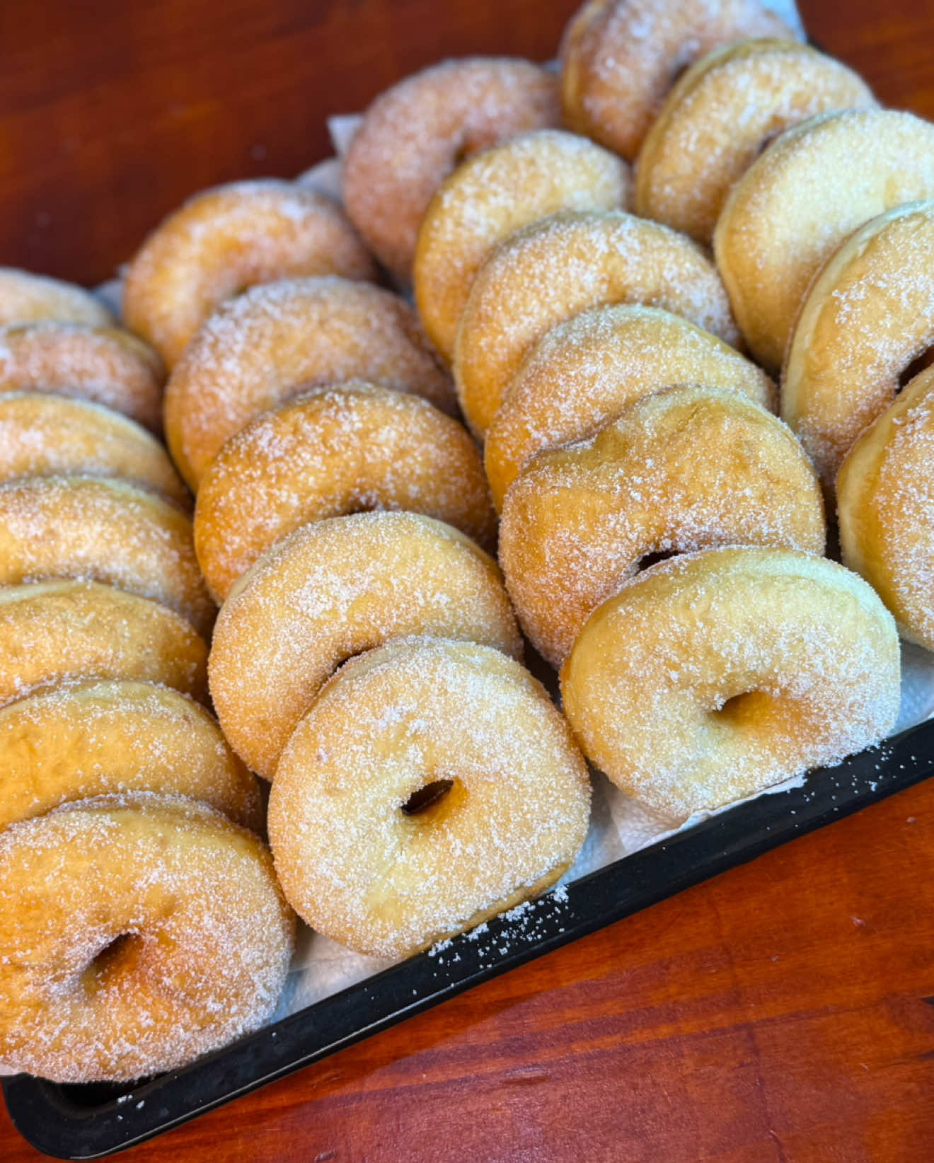 DONAS PARA VENDER, LA RECETA MÁS VIRAL DE MI PERFIL EXPLICADA PASO A PASO😍 Ingredientes: salen entre 36 a 40 unidades  Harina 0000 1kg 2 huevos  Manteca o margarina 50gr Levadura fresca 30gr Agua tibia 400cc Azúcar 120gr Ralladura de limón  ✅Comenzamos activando la levadura, para esto en un recipiente colocamos el agua tibia junto con la levadura fresca, una cucharada de azúcar y una de harina. Dejamos reposar unos minutos y luego en un bowl amplio colocamos la harina, en el centro los huevos con el resto del azúcar, la ralladura de limón, la margarina y el fermento previamente hecho.  Amasamos unos cinco minutos, y dejamos reposar solo diez minutos. Estiramos de un dedo de grosor, cortamos las donas y las dejamos reposar en la mesada con bastante harina. Dejamos leudar una hora y media aproximadamente y luego freímos en abundante grasa vacuna bien caliente, unos 30 segundos por lado. A medida que salen de la fritura, las colocamos sobre papel absorbente durante un minuto y luego rebosamos en azúcar.  #donas #rosquitas #panaderia #mate 