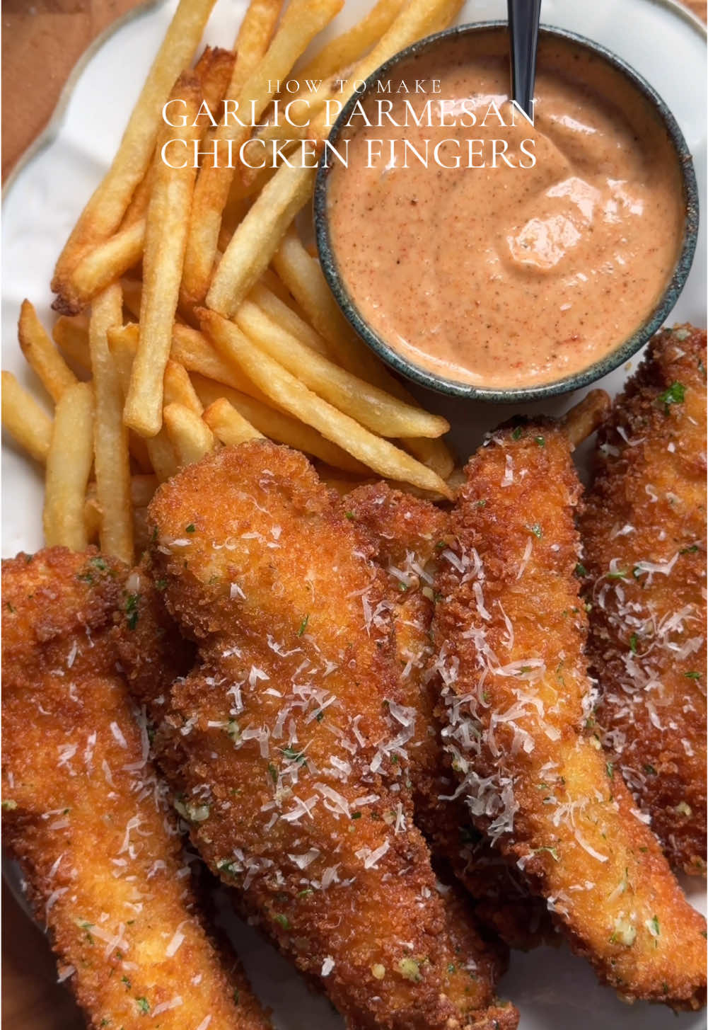 Crispy Garlic Parmesan Chicken Strips with Creamy Chili Sauce Ingredients: For the Chicken: - 2 lb chicken breast, cut into strips - Salt to taste - 1 tbsp garlic powder - 1 tsp black pepper powder - Oil for frying For the Dry Batter: - 2 cups all-purpose flour - Salt to taste - 1 tbsp garlic powder - 1 tsp black pepper For the Egg Mixture: - 3 eggs For the Breadcrumb Coating: - 2 cups panko breadcrumbs  For Garlic Parmesan Butter: - 1/2 cup butter - 4-5 cloves fresh garlic, finely chopped - 2 tbsp freshly chopped parsley - 1 cup Parmesan cheese, freshly grated For the Sauce: - 1/2 cup mayonnaise - 2 tbsp ketchup - 1-2 tbsp chili sauce (adjust to taste) - 1/2 tbsp Dijon mustard - Salt to taste - 1 tsp smoked paprika powder - 1 tbsp garlic powder - 1 tsp black pepper powder Method: 1. Season the Chicken: Sprinkle salt, garlic powder, and black pepper powder over the chicken strips. Mix well to ensure even coating. 2. Prepare the Dry Batter: In a bowl, mix together flour, salt, garlic powder, and black pepper. 3. Prepare the Egg Mixture: Beat the eggs in a separate bowl. 4. Prepare the Breadcrumb Coating: Place panko breadcrumbs in another bowl. 5. Coat the Chicken: Dip each seasoned chicken strip into the flour mixture, then the egg mixture, and finally the breadcrumb mixture, ensuring an even coat. 6. Fry the Chicken: Heat oil in a deep frying pan over medium-high heat. Fry the coated chicken strips until golden brown and crispy. (for about 5-6 minutes flipping sides in between ) 7. Make Garlic Parmesan Butter: In a pan heat butter once melted add minced garlic. Sauté for 1 min until fragrant. Remove and set aside  8. Prepare the Sauce: In a bowl, combine mayonnaise, ketchup, chili sauce (to taste), Dijon mustard, salt, smoked paprika powder, garlic powder, and black pepper powder. Mix well. 9. Serve:Toss the fried chicken strips with garlic butter. Top it with freshly grated Parmesan cheese and freshly chopped parsley. Serve with creamy chili sauce for dipping. #chickentenders #chickenfingers #crispychicken #garlicparmesan #Recipe 