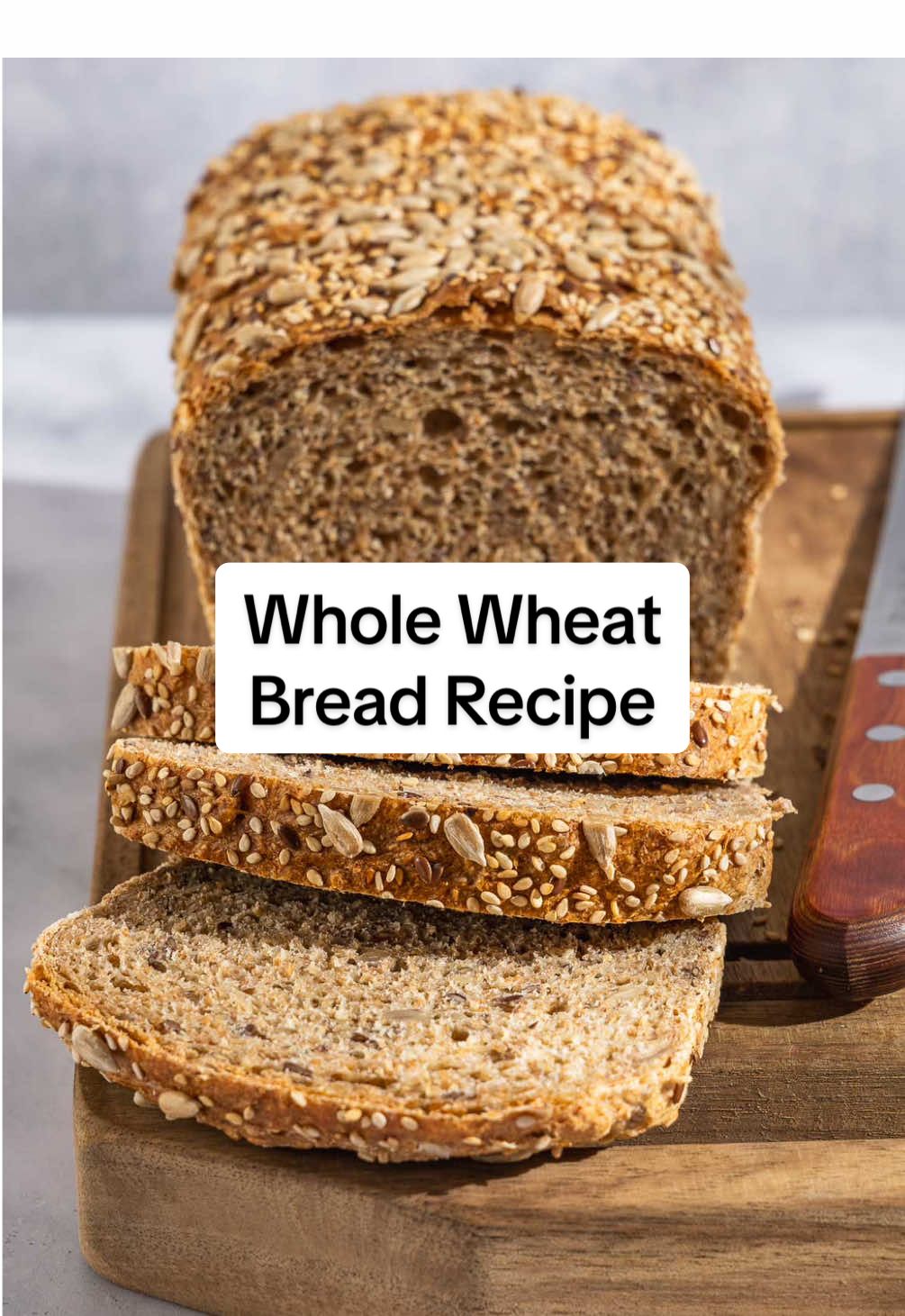 Homemade Whole Wheat Bread Recipe - learn how to make seeded whole wheat bread with this easy bread recipe!  Making your own bread at home doesn’t require as much time as you might expect, especially when you consider it’s mostly hands-off. Storebought bread doesn’t get stale as quickly as homemade bread–almost frighteningly so—but you will get a few days out of this one. Plus, it comes back to life with a quick trip to the toaster! This simple list of ingredients bakes into a nutty, wholesome sandwich bread, and it can easily be made vegan. This bread is a great way to use up partial bags of seeds in your cupboard, or you can use a blend of your favorites. Here’s what you’ll need: For The Dough ▢ 1/2 cup (70g) mixed seeds, such as flax, sunflower, and sesame ▢ 2 3/4 cups (330g) whole wheat flour ▢ 1 cup (120g) all purpose flour (see note) ▢ 1 tablespoon (9g) kosher salt ▢ 1 tablespoon instant yeast ▢ 1 1/4 cups (300ml) hot water (105 to 115°F) ▢ 2 tablespoons extra virgin olive oil, plus more for greasing ▢ 1 tablespoon honey For The Topping ▢ 1 large egg ▢ 1 tablespoon water ▢ 1/4 cup (35g) mixed seeds, such as flax, sunflower, and sesame 1. Toast the seeds: Spread the seeds on a baking sheet and toast in a 350°F oven for 5 to 10 minutes. 2. Mix the dry ingredients: Whisk together the whole wheat flour, all-purpose flour, toasted seeds, salt, and yeast. 3. Add the wet ingredients: Pour in the water, olive oil, and honey. Mix until the dough comes together into a rough ball. 4. Knead the dough: Scrape the dough onto a lightly floured surface. Knead by hand for 10 minutes until smooth. At first, the dough will seem too sticky, but it will become more manageable as you knead it. 5. First rise: Shape the dough into a taught ball. Grease a clean bowl with a thin layer of olive oil and place the ball of dough in the bowl. Cover and leave it in a warm place to rise for about 1 hour. 6. Shape the dough: Grease a loaf pan with olive oil and set aside. Lightly dust a clean work surface with flour. Place the dough upside down on the surface so the smooth side is facing down. Gently press and stretch the dough to shape it into a square the same width as the bottom of the loaf pan. Roll the dough into a log and pinch the seam. Place the loaf in the greased pan. 7. Add the mixed seed topping: Brush the top of the loaf lightly with egg wash. Sprinkle the top with 1/4 cup of untoasted mixed seeds. 8. Proof: Cover the pan loosely. Leave it in a warm place to rise for 30 minutes to an hour. 9. Preheat the oven and bake: Bake the loaf in a 350°F oven until it’s golden brown, 50 to 60 minutes.  10. Cool: Remove the loaf from the pan and set it on a rack to cool. Let it cool completely before slicing. This seeded whole wheat bread recipe is perfect for all kinds of sandwiches, open-faced sandwiches, and toast. #breadrecipe #homemadebread #wholewheatbread #breadmaking #easybread 