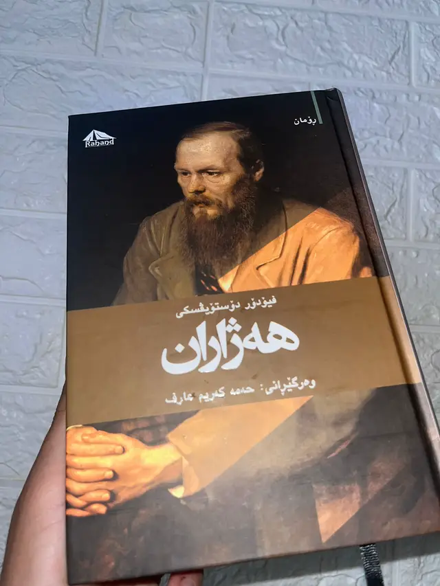 “هەژاران… ناوی کتێبێکە، بەڵام بە شێوەیەکی جوان‌تر بڵێین: دەقی ژیانە. لە ڕووسییەوە ناوی ‘Бедные люди’ ـە، بە زمانی ئینگلیزی ‘Poor Folk’ و بە کوردی ‘هەژاران’ ـ ژمارەی یەکەم ڕۆمانی فیۆدۆر دۆستۆیۆفسکی. لە کاتی تێکچووی روسیا، لە شەقامە کۆنەکان، دوو دڵ هەیە کە بەنامە گۆی لەگەڵ یەک دەکەن: ماکار دێڤوشکین، پیاوێکی فەقیر، و ڤارڤارا، ژنێکی هەژار و تاوانبار لە خۆی. لەوانەیە پارەیان نەبێت، بەرپرسیارییەکی گەورە نەبێت، بەڵام ھەستیان پڕە لە خەیاڵ، دڵسۆزی، و خوێندنی جەهێکی نیشتمانە ـ ئەو جیهانەی دۆستۆیۆفسکی دەخەیە ژوورەوە، بە شێوەیەکی تەنها ئەوەی توانای نووسینی دەبێت. ‘هەژاران’ دەڵێت: فەقیر تەنها بێ پارەبوون نییە، فەقیر بریتییە لە ئەوەی بێ کەس بیت، بێ گوێگر، بێ دڵی تر، بێ ئەو کەسی کە بفەهمێت تۆ لە شتێکت خۆشبەختی دەبینیت. ئەم ڕۆمانە خشتەیەکە بۆ ئەوەی بزانین چی دەکات لەگەڵ دڵی مروڤ لە کاتی زەحمت، و چون هەستی هاوڕێیی دەتوانێت ژیانێک ڕەنگ بکات، هەر ئەگەر جێگای نان و پان بەسەربچێت. ئایا تۆش هەندێکجار باسی خۆت کردووە بە ناوی “هەژار”؟ باسی هاوڕێکت؟ باسی دڵەکاوت؟ ئەوا ئەم کتێبە پێویستی تۆیە. #fyp #foryou #foryoupage #viral #fy 