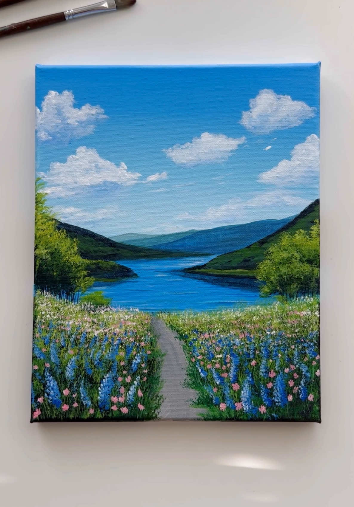 The Wildflower Path 💙🌺🌸🌿🎨  . . . . . . . . . . . . . . . . . . . . . . . . . #acrylicpainting #canvasart #howtopaint #abminiart #cloudspainting #landscapeartwork #abminiart #aestheticart #creative #viralart #fypシ゚viral #artok #fypシ゚ #mountains #natureview #chillvibes #acryliconcanvas 