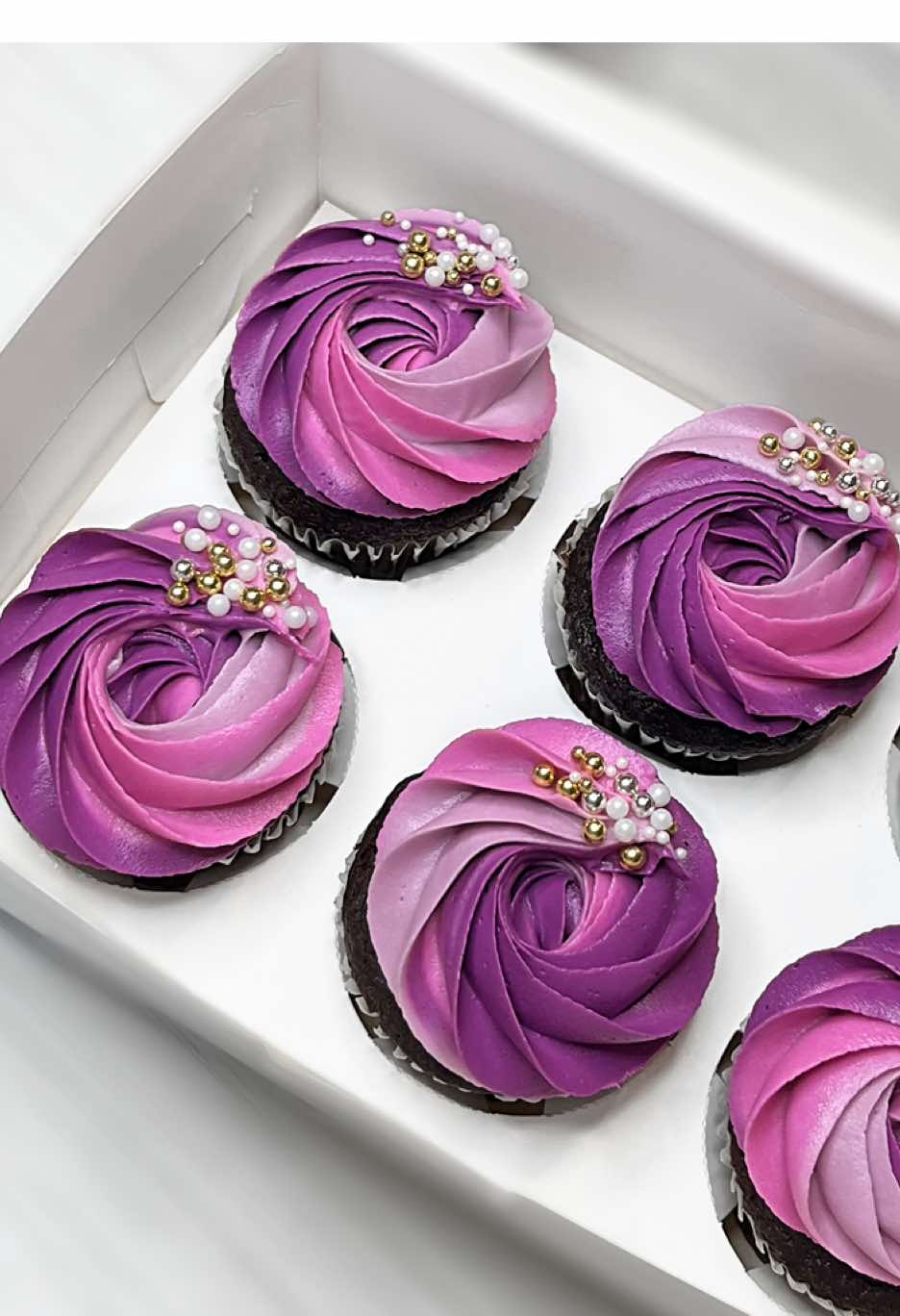 Let’s make multi-colored  buttercream swirls using piping tip 1G in the prettiest shades of purple ✨💟🫶🏻 multi colored swirls using my favorite method: spreading the colored buttercream side by side on plastic/cling wrap, roll it up, cut off the end, place the rolled buttercream into your prepared piping bag (with the piping tip already inside), and then pipe your beautiful colorful buttercream swirls✨ . TIP: after you have rolled up your buttercream (and before placing it in the piping bag), use your fingers to gently press out all the air bubbles. I do this a couple times on all sides. This will help eliminate those annoying air bubbles that pop up as you are piping!  . Piping tips: Wilton 1G . #cakedesign #cakeideas #cakeinspo #cupcakes #cakeinspiration #americanbuttercream #chocolatecake #pipingskills  . . Chocolate cupcakes. Cupcake. Cake. American buttercream. Piping video. Cupcake video. How-to reel. Tutorial. Cake video. 2025. Baking. Baked goods. Decorating tip.