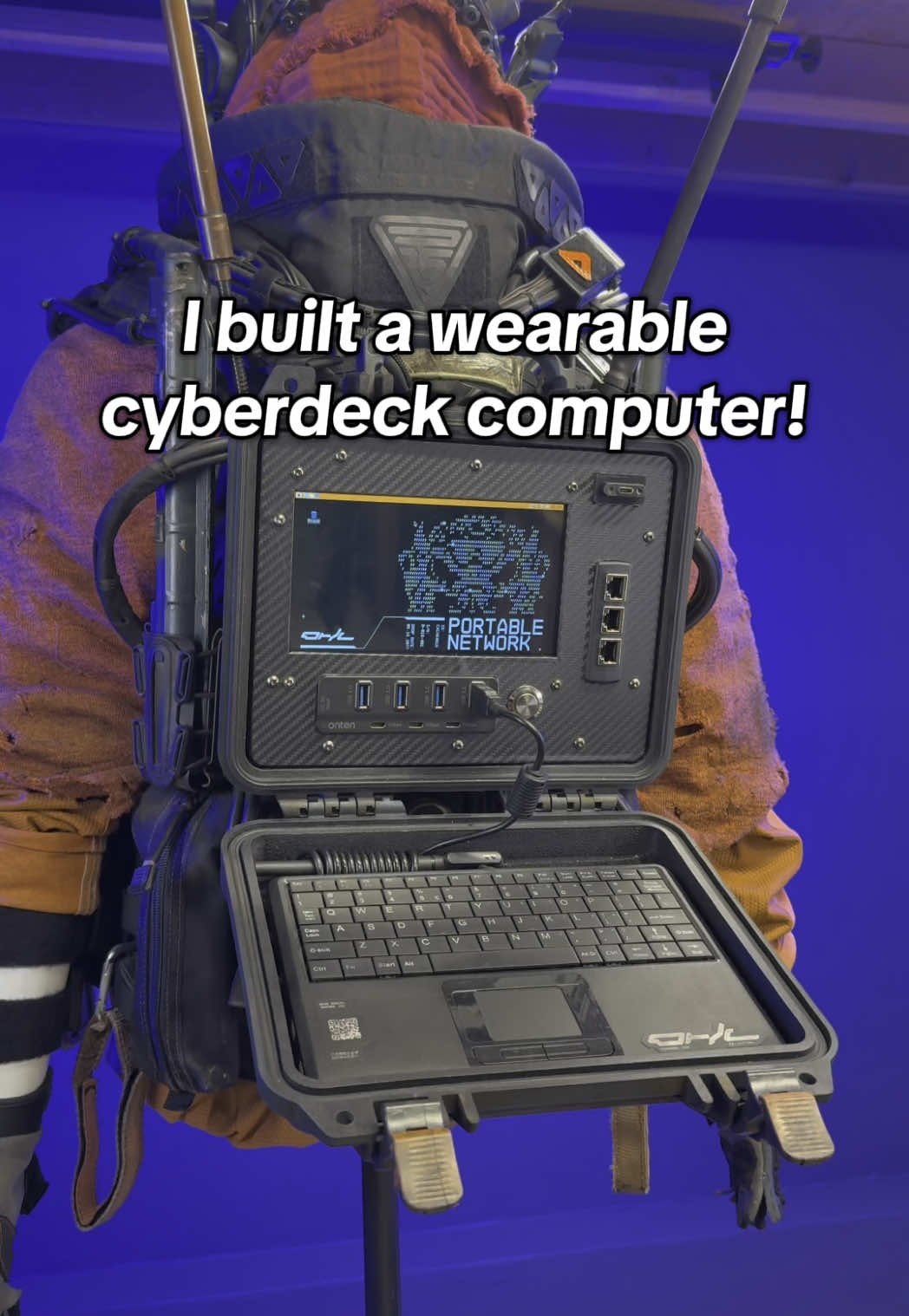 Testing my custom portable cyberdeck while integrated into my cyberpunk network operator costume! Where would you wear something like this?  I built this #cyberdeck from scratch and made it adaptable to the custom droid jacket I made. It attaches via buckles and clips and is super sturdy. It can be used by a buddy or removed and used by the wearer.  I painted and customized a @pelican case that houses the cyberdeck, and it’s completely waterproof when closed. The @raspberrypi OS can operate regardless of the case being open or not, and it’s up to the user to determine what it can do. Let me know what you’d do with this! #cyberpunk #cyberpunkaesthetic #cyberpunkstyle #cyberpunkfashion #propmaker #cosplaycommunity 