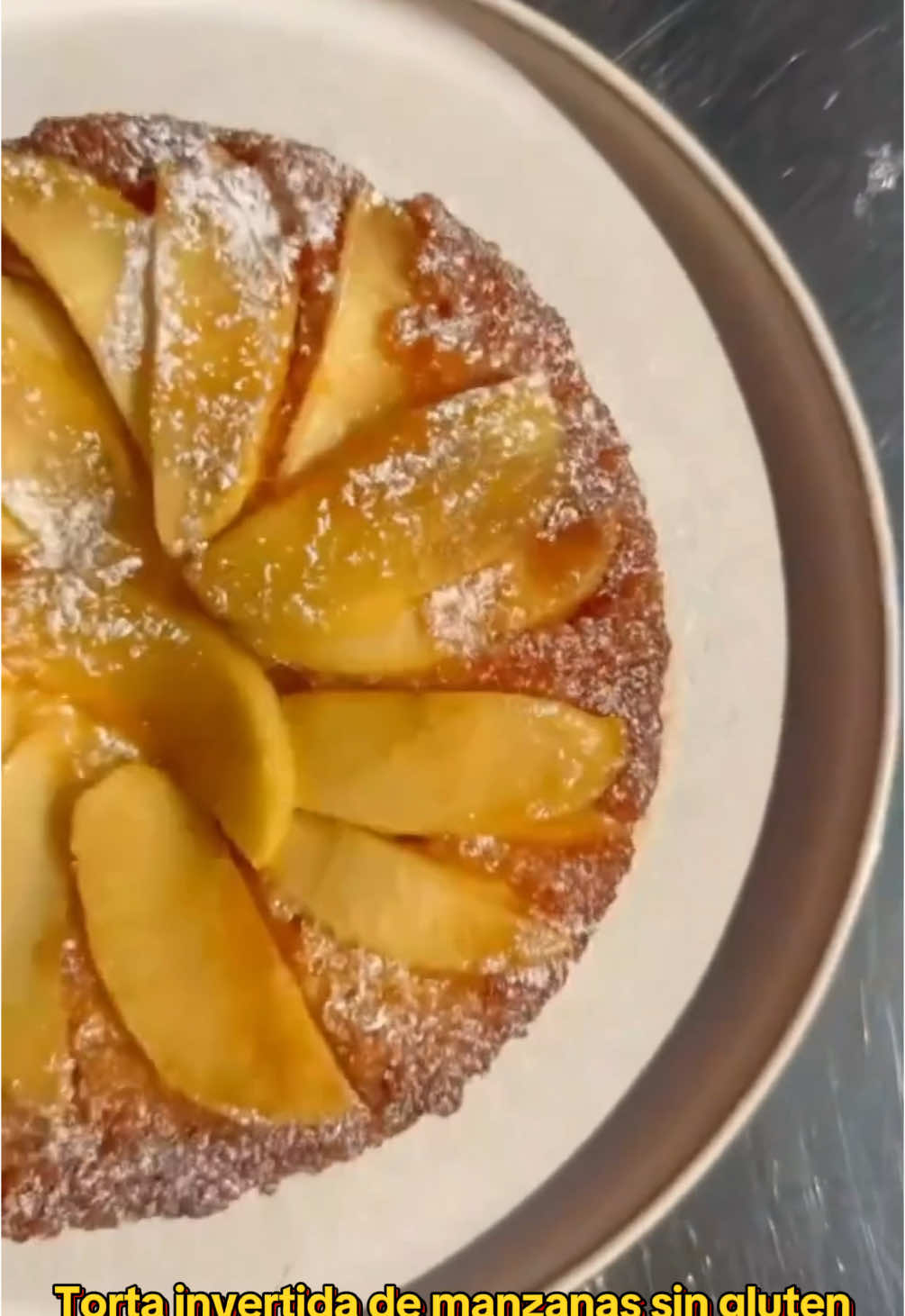 TORTA INVERTIDA DE MANZANAS SIN GLUTEN🍎  Paso 1 : CARAMELO: 150 g de azúcar + 50 cc de agua + gotitas de jugo de limón  INGREDIENTES TORTA: 🍎 2 manzanas 🍎 peladas y cortadas en gajos gruesos  125 g de manteca pomada 200 g de azúcar 3 huevos 50 ml de leche 230 premezcla sin gluten ( si es casera agrégale 1 cda de goma xantica )  2 cditas de polvo para  hornear 1 cdita de esencia de vainilla Ralladura de 1 limón ( opcional )  Paso 2: Preparación: 🍎 Colocar las manzanas sobre un molde enmantecado colocarle el caramelo por encima. Por otro lado batir la manteca con el azúcar, cuando está cremosa incorporar los huevos de a uno y la ralladura del limón seguir mezclando agregar la esencia de vainilla y la premezcla junto el polvo de hornear intercalando con la leche. Volcar la mezcla sobre las manzanas 🍎  Llevar a horno precalentado 180 grados por 40 minutos o podes hacer la prueba del palito limpio.  Desmoldar el caliente así el caramelo no se vuela e a pegar a la base le podes colocar coco que le da un toque Gourmet 👌 Si te gusto compartila con los amantes de las tortas frutales y fáciles  😉 #sintacchayparaiso #recetafacil #manzana #torta #glutenfreetiktok 