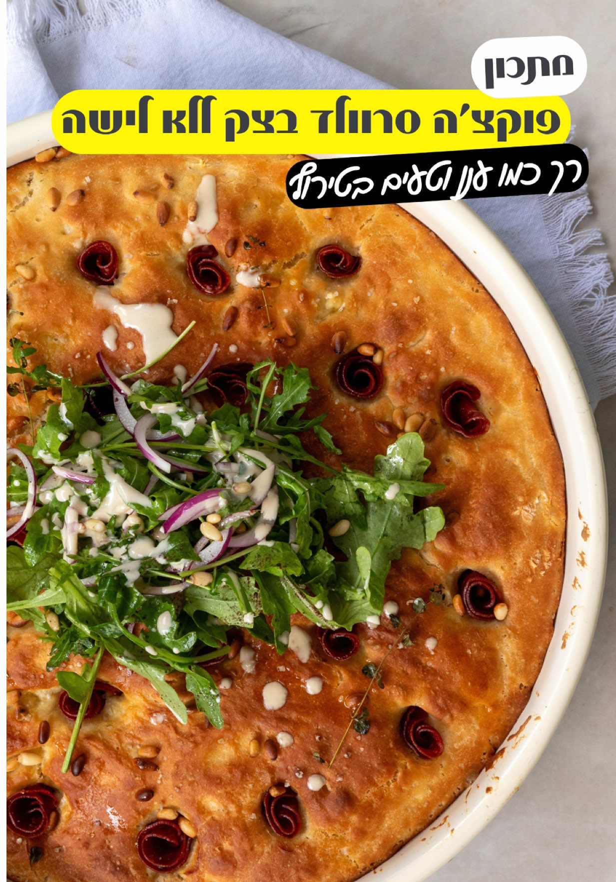 ‎פוקצ׳ה סרוולד שמכינים ללא לישה , טעימה ורכה כמו ענן  ‎השתמשתי בסרוולד בסגנון צרפתי של טירת צבי מסדרת הדליקטיב ומה אגיד לכם זה באמת דליקטס  ‎מצרכים: ‎לבצק: ‎- חצי קילו קמח לבן מנופה ‎- 450 מ״ל מים פושרים ‎- כף שמרים יבשים (5 גרם) ‎- כף סוכר  ‎- כף שטוחה מלח ‎- 3 כפות שמן זית  ‎לטופינג ‎- חצי חבילה(60 גרם)נקניק סרוולד בסגנון צרפתי טירת צבי ‎- חופן צנוברים ‎- 3 כפות שמן זית ‎- כפית מלח גס ‎- 4 גבעולי טימין ‎להגשה: ‎- סלטון עלי רוקט עם בצל סגול מתובל במלח פלפל שמן זית ‎- טחינה דלילה  ‎אופן ההכנה: ‎- בקערה שמים את המים הפושרים השמן זית השמרים והסוכר ומערבבים, נותנים לזה לנוח כ20 דקות עד שיווצרו בועיות כמו בסרטון ‎- מוסיפים את המלח והקמח ומערבבים בעזרת כף עץ  ‎- מכסים ומתפיחים לשעה  ‎- מעבירים לתבנית עגולה או מרובעת משומנת בשמן זית  ‎- מניחים את הבצק וטיפה דופקים או פותחים עם היד ‎- מכסים ונותנים עוד התפחה של כ 30 דקות ‎- לוקחים נקניק סרוולד מקלים לחצי ומגלגלים לפרח ‎- תוקעים בכל הבצק חתיכות של הסרוולד ‎- זולפים שמן זית מפזרים מלח גס ושמים טימין  ‎- מחממים תנור ל200 מעלות מכניסים את הפוקאצה לאפייה של כ30 דקות  ‎- מגישים עם סלטון שמכינים מרוקט בצל סגול שמן זית לימון ומלח  ‎- זולפים טחינה ומגישים באהבה  ‎- בתאבון ‎פרסום ממומן בשיתוף @tirat_zvi  ‎#פוקצה #פוקצהללאלישה #סרוולד #יאבלולושמבלולו 