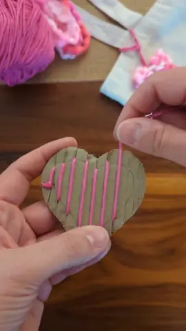 Cardboard Loom Weaving Mother's Day Bag Charm ♥️ We used some of our fuzzy pink yarn to make these heart bag charms for Mother's Day! I cut notches along the top and bottom of a small cardboard heart and wrapped yarn around the cardboard and behind the tabs. I threaded a yarn needle and started weaving from the bottom. Once you reach the top you can pull the yarn off the loom. I added a loop of yarn to the back of the yarn and tied the heart to a tote bag! #kidcrafts #easycrafts #cardboardcrafts #mothersday #mothersdaygift