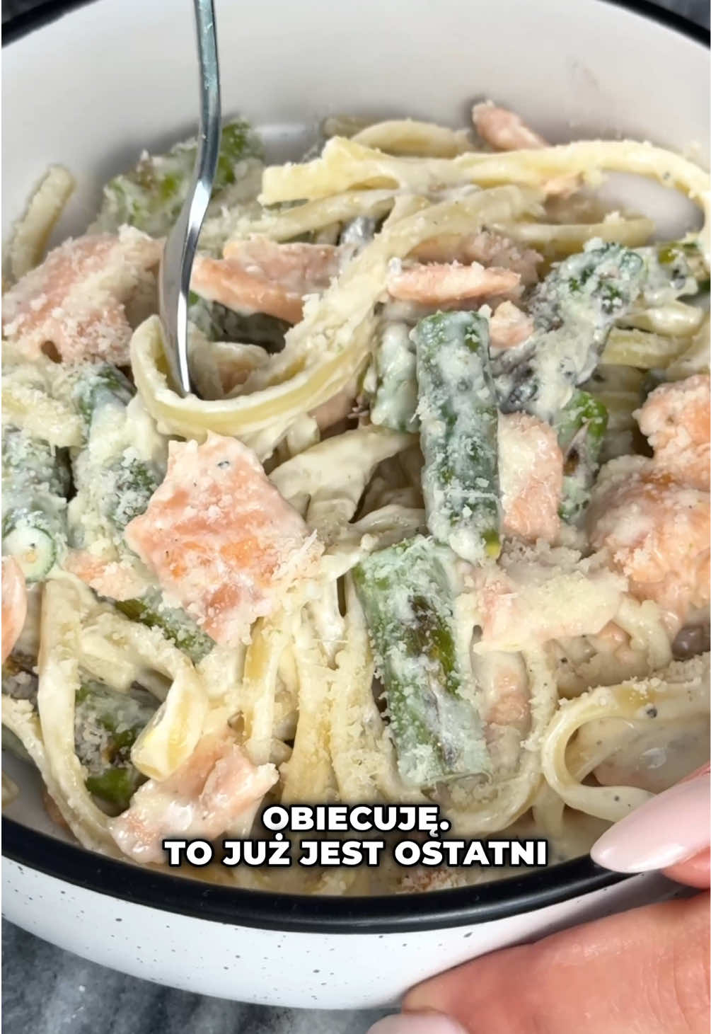 Makaron ze szparagami i łososiem 😍 Przepis (2 porcje): 120g makaronu •100g łososia wędzonego na zimno •2 ząbki czosnku •8 szparagów •80g serka naturalnego (takiego kanapkowego) •około 100ml wody z gotowania makaronu •20g parmezanu lub grana padano •sól, pieprz •oliwa •odrobina soku z cytryny  1️⃣ Szparagi myjemy, odcinamy twarde końcówki i kroimy wszystkie na 4 części. 2️⃣ Makaron gotujemy według opakowania. Pod koniec gotowania odlewamy trochę wody, przyda się do sosu. 3️⃣ Na patelni na oliwie podsmażamy szparagi, po chwili dodajemy pokrojony czosnek. Wszystko razem smażymy około 5 minut.  4️⃣ Doprawiamy solą i pieprzem, dodajemy serek śmietanowy i wodę z gotowania makaronu oraz odrobinę soku z cytryny. Dokładnie mieszamy. 5️⃣ Dodajemy makaron, grana padano i kawałki łososia, dokładnie mieszamy i gotowe.  ❗️Porcja: 503 kcal B:25g T:22g W:53g #przepis #furajedzenia #szparagi #makaron #pasta #asparagus #obiad 
