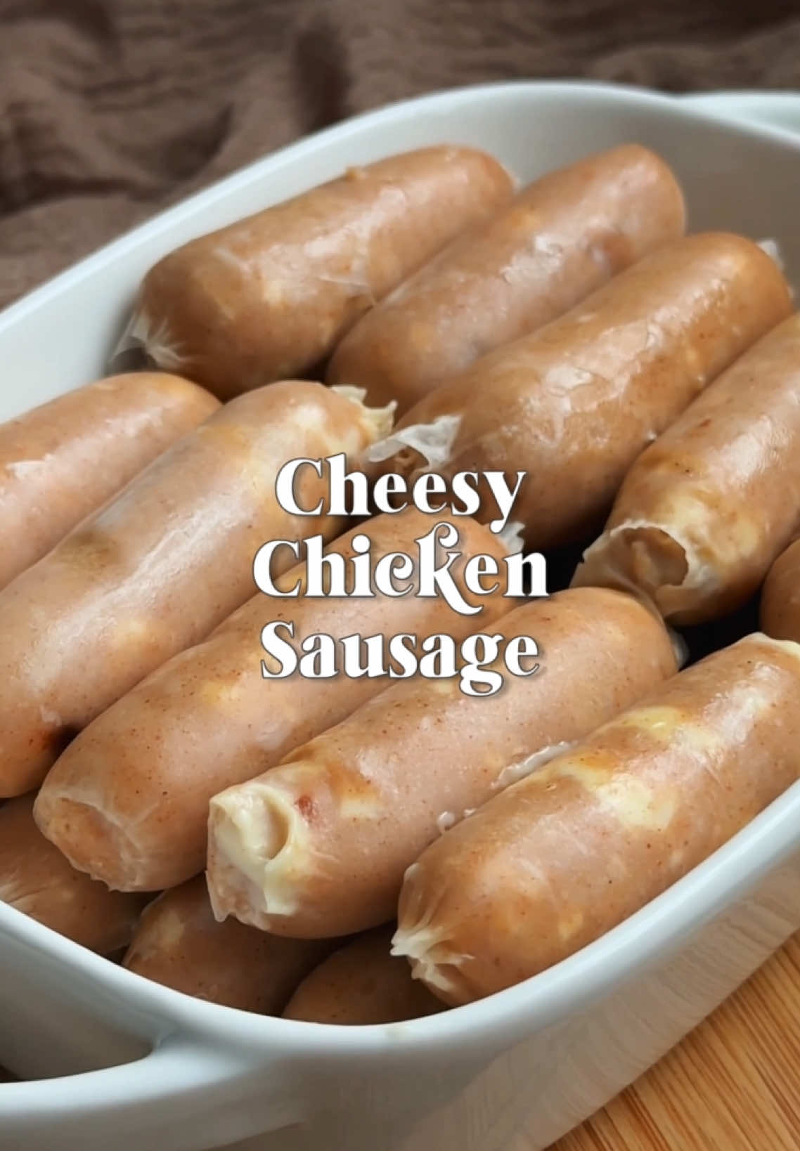 Lumer, gurih, dan siap jadi andalan jualan! Bikin Homemade Cheesy Chicken Sausage gak pernah semewah ini✨🧀 Cukup modal dapur rumah dan @Keju Kraft Quick Melt Mozza ✨ Bayangin... potongan sosis homemade dibelah, terus kejunya meleleh keluar🤤 Teksturnya lembut, rasanya creamy, dan tampilannya? Auto bikin pelanggan repeat order! Cocok buat kamu yang mau mulai usaha kuliner dari rumah tanpa ribet. Sekali coba, pasti nagih. Mulai dari dapur, bikin usaha kuliner jadi lumer ke mana-mana! HOMEMADE CHEESY SAUSAGE  500 GR PAHA AYAM FILLET 100 GR ES BATU 4 SDM TAPIOKA 1 SDT BAWANG PUTIH BUBUK 1 SDT BAWANG BOMBAY BUBUK 1 SDT PAPRIKA POWDER 1/2 SDT BAKING POWDER 1 SDT GARAM 2 SDT KALDU JAMUR 1/2 SDT LADA PUTIH 2 BUTIR PUTIH TELUR 100 GR KRAFT QUICK MELT MOZZA KULIT SOSIS SAUSAGE STUFFER TRUSSING STRING CARA MEMBUAT :  	1.	Masukkan ayam dan es batu ke dalam chopper, haluskan. 	2.	Setelah halus masukkan bahan lainnya, chopper kembali. 	3.	Masukkan potongan kraft quickmelt, aduk hingga adonan merata. 	4.	Isi adonan sosis ke dalam kulitnya menggunakan sausage stuffer, kemudian ikat dengan trussing string lalu tusuk-tusuk sosis dengan jarum. 	5.	Rebus menggunakan api kecil selama 5-10 menit atau hingga sosis matang. 	6.	Lepas tali ikatan lalu potong sosis sesuai ukuran, tiriskan. 	7.	Grill sosis dengan minyak sedikit hingga matang, sajikan.