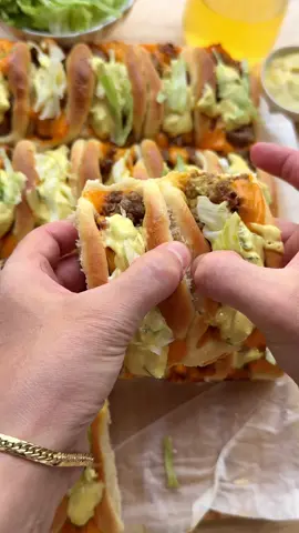 BIG MAC PARTY BUNS #food #recipe #bigmac #party #buns #beef #tasty #foryou #fyp DOUGH 225 ml lukewarm milk 7 g instant yeast (1 tablespoon) 15 g honey 1 medium egg 35 ml sunflower oil 450 g flour (all-purpose flour) 8 g salt (1⅓ teaspoon) BEEF MIXTURE 25 ml sunflower oil 500 g ground beef 3 g salt (½ teaspoon) 1.5 g black pepper (½ teaspoon) 50 g cheddar cheese SAUCE 175 g mayonnaise 40 g mustard 50 g pickles (±2, finely chopped or grated) 10 g yellow onion (grated) GARNISH cheddar cheese lettuce INSTRUCTIONS Add the lukewarm milk, yeast, and honey to a large bowl. Mix well and let it rest for 5 minutes. Add the beaten egg and sunflower oil. Mix well. Then add the flour and salt. Knead for 10–12 minutes until smooth. Cover and let the dough rise for 1 hour, or until it has doubled in size. Heat the sunflower oil in a skillet over medium heat. Add the ground beef, salt, and black pepper. Cook the beef until browned and crumbly, about 7–8 minutes. Add the cheddar cheese to the meat and stir until the cheese has melted and the mixture thickens slightly. Set aside and let cool a bit. In a separate bowl, mix the mayonnaise, mustard, grated pickles, and grated onion into a smooth sauce. Set aside. Deflate the dough and divide it into 20 equal portions (about 35 grams each). Shape into balls. Roll each ball into a circle of about 9 cm in diameter. In the center, place half a slice of cheddar cheese, a small spoon of sauce, and a spoonful of the beef mixture. Fold the edges of the dough inwards to enclose the filling. Place the filled dough on a parchment-lined tray. Let it rise again for 30 minutes, until doubled in size. Preheat the oven to 200 °C (390 °F). Bake the rolls for 15–25 minutes until golden brown and cooked  through. Every oven is different, so keep an eye on the baking time. Carefully remove the rolls from the oven and top with a bit of cheddar cheese. Garnish the warm rolls with extra sauce and finely shredded iceberg lettuce.