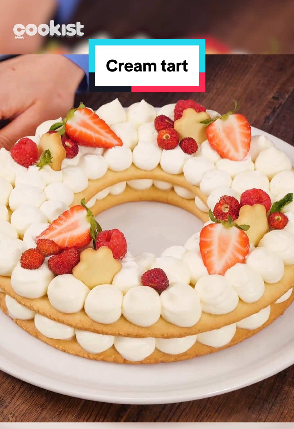 🎂 VUOI FARE COLPO? Prova la Cream Tart, è perfetta per compleanni e occasioni speciali! Strati di frolla, crema golosa e una decorazione che lascia tutti a bocca aperta🤩 👩🏼‍🍳La nostra Melissa ci fa vedere come prepararla: 👉INGREDIENTI Per la pasta frolla:  500g di farina  250g di burro  2 uova  estratto di vaniglia  250g di zucchero a velo  sale  Scorza di limone Per il ripieno 500g di mascarpone freddo 450ml di panna fresca 230g di zucchero a velo Per decorare  12 lamponi 10 fragole foglie di menta    👉PREPARAZIONE 1. Prepara la pasta frolla. Sciogli il burro nella farina con le mani insieme allo zucchero a velo, a un pizzico di sale, scorza di limone e vaniglia. Dovrai ottenere un composto sabbioso.  2. Aggiungi le uova e mescola. Quando avrai ottenuto un composto compatto impasta con le mani formando un panetto e copri con pellicola alimentare. Metti in frigo per almeno 30 minuti. 3. Dividi in due il panetto e stendi le due metà formando dei dischi uguali non troppo sottili. 4. Mettili su carta forno e ricava le forme: noi abbiamo usato uno stampo per torta da 24cm e un coppapasta per il buco al centro di 12cm. 5. Rimuovi gli eccessi, potrai usarli per fare dei biscottini per decorare la torta alla fine.  6. Inforna i dischi a 175°C per 15 minuti, devono dorarsi leggermente senza bruciarsi. 7. Intanto prepara la crema mescolando mascarpone, zucchero a velo e la panna fredda. Monta con le fruste fino ad ottenere una bella crema densa.  8. Una volta sfornati i dischi, lasciali raffreddare, metti la crema in un sac à poche e riempi di ciuffetti tutta la superficie del primo disco.  9. Ricopri con il secondo disco e riempi di ciuffetti di crema.  10. Decora come preferisci, noi abbiamo usato fragoline, biscottini, fragole e lamponi. #cookist #creamtart #ConSantanderConecto 
