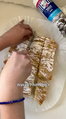מאפה פילו: עוגת מניפה משגעת לחג שבועות, תוך פחות מ10 דקות ויש לכם קינוח מרשים, טעים ומקורי. שיהיה בתיאבון וחג שמח.   מצרכים: 1 חבילה של בצק פילו מופשר 50-70 גרם חמאה מומסת 1 צנצנת חלב מרוכז הנמל 2 ביצים 3\4 כוס חלב ½ כפית תמצית וניל אבקת סוכר לפיזור   אופן הכנה: 1. לוקחים תבנית מלבנית ומודדים בתוכו את גודל בצק הפילו, חותכים את הקצה כך שגליל בצק הפילו יתאים ברוחב לתבנית. 2. פורסים על משטח העבודה דף פילו, מברישים אותו בחמאה ומעליו שמים דף פילו נוסף, גם אותו נבריש בחמאה. 3. נקפל בצורת מניפה\אקורדיון את שני דפי הפילו המחוברים והמוברשים ונניח בתבנית מרופדת בנייר אפייה מרובע של הנמל. נחזור על הפעולה עד שנגמרים כל דפי הפילו והמקום בתבנית. 4. מכניסים לתנור שחומם מראש על 180 מעלות למשך 20 דקות עד להזהבה. 5. בינתיים מכינים את הבלילה- בקערה מערבבים את שאר המצרכים עד לקבלת תערובת חלקה ואחידה. 6. כשהעוגה יוצאת מהתנור מוזגים עליה את הבלילה ומכניסים שוב לתנור לעוד 15-20 דקות עד להזהבה והתייצבות. 7. נותנים לעוגה להצטנן מעט בטמפרטורת החדר ומפזרים עליה אבקת סוכר בנדיבות. פורסים ובתיאבון. *ניתן לאכול את העוגה חמה וקרה. תוכן בשיתוף ממומן @הנמל 