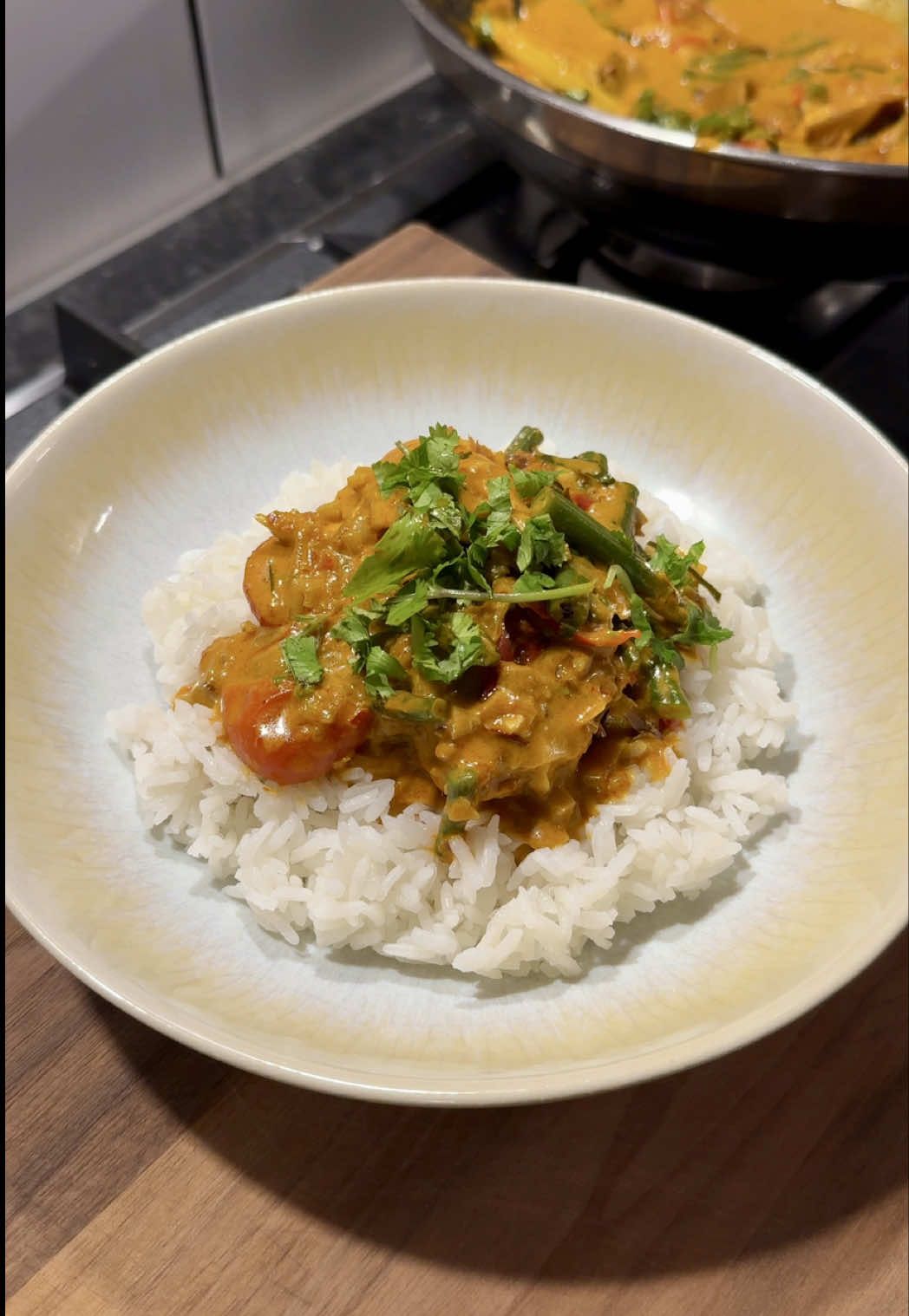 How to make my mum’s iconic Malaysian sambal fish curry 🐟! All the flavour with minimal effort - perfect weeknight or weekend / date night dinner. It’s rich, delicious and proper comforting, this curry will transport you straight into a Malaysian kitchen with an auntie telling you to eat more Serves 4 Mum’s tip: cure the fish in lime juice to reduce any “fishy” smell/taste. Lime juice also slightly helps firms the fish up For the base: 3 banana shallots 30g ginger 1 bulb of garlic 1 lemongrass 4 kaffir lime leaves 1 red chilli 1/2 torch ginger flower (optional) 10g coriander For the seasonings and sauces: 2 tbsp curry powder (we like Baba’s) 1 tsp turmeric 1/2 tbsp salt 1/2 tbsp white pepper 1 tsp sugar 1 tsp chilli flakes 120ml water 200ml coconut cream (we like Kara) 1 tbsp fish sauce 2 tbsp @Mama Yu Sambal  1 lime 4-6 pieces of cod loin (or any white fish) 5 tbsp vegetable oil 200g green beans 10 baby tomatoes 4 bowls of rice, to serve per person 4 tbsp Mama Yu Sambal, to serve per person  Squeeze the juice of 1/2 a lime over the cod loins. Set aside to lightly cure while you prepare the aromatics. Finely chop the shallots, mince the garlic, bash the lemongrass and cut lengthways into 3 pieces. Place the kaffir lime leaves on top of each other, roll and finely shred. Slice the red chilli, separate the torch ginger leaves and shred finely like the lime leaves. Roughly chop the coriander.  In a wok or large pan, heat vegetable oil over medium heat. Add the white aromatics - shallots, garlic and lemongrass. Fry until fragrant for about 2-3 minutes.  Add the curry powder, turmeric, salt, white pepper, sugar and chilli flakes. Cook for another minute until the spices toast and release aroma.  Pour in the water and coconut cream. Add fish sauce, sambal and the remaining juice of 1/2 the lime. Stir, mix well and bring to a simmer. Add green beans, tomatoes, red chilli, shredded torch ginger flower (if using) and shredded kaffir lime leaves - mix well.  Gently place the cured cod loins into the curry. Spoon some sauce over the top. Cover with a lid and let cook for 6-8 minutes, depending on the thickness of the fish, until just cooked through.