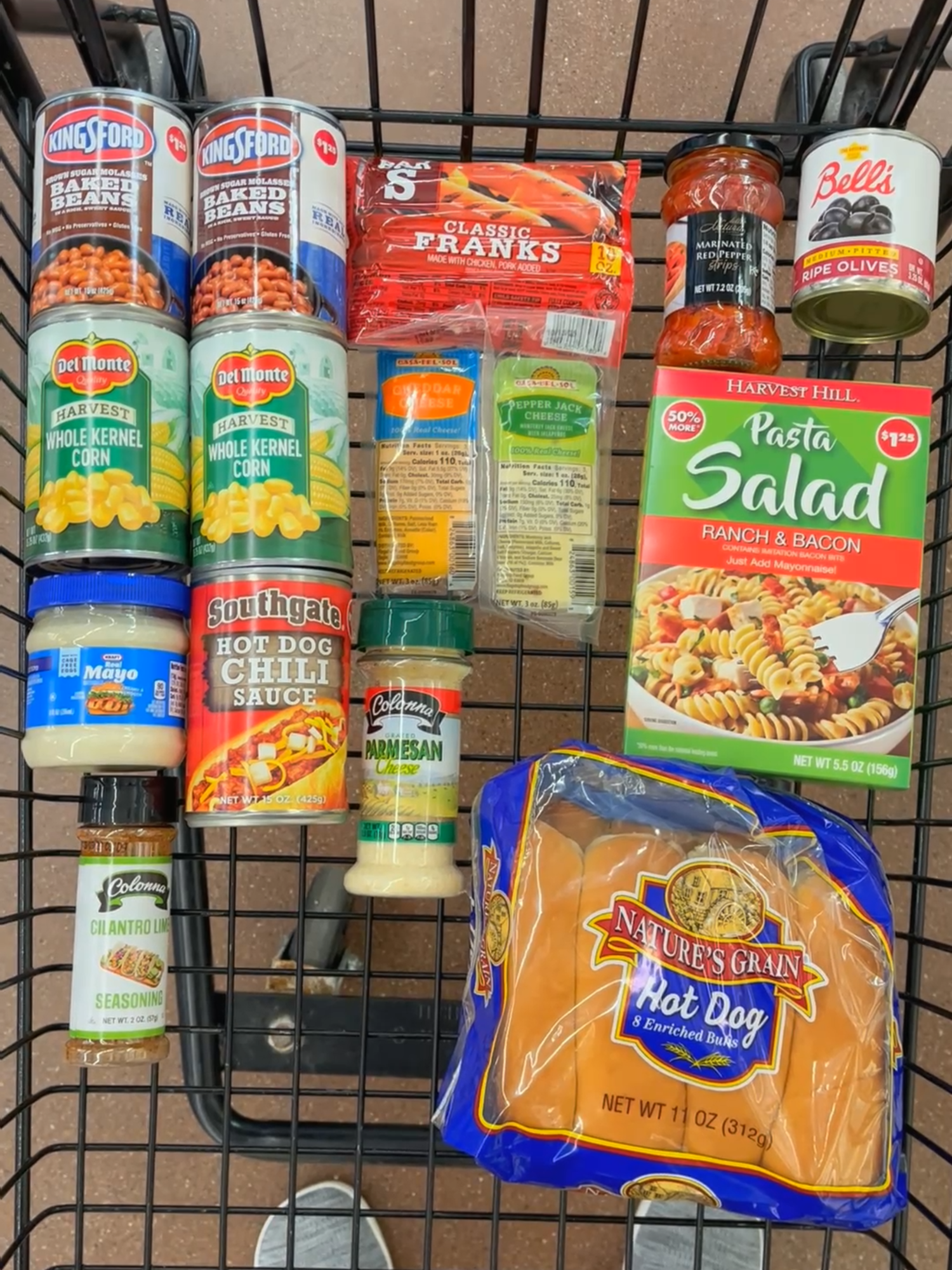 I had a $20 budget to pull off a summer BBQ for four, and I grabbed everything from @Dollar Tree! This is perfect for a low key summer hangout, and yep...I even had a dollar to spare! Shopping list: Hot Dogs (1 pack, classic, chicken or turkey) $1.25 Hot Dog Buns $1.50 Hot Dog Chili $1.25 Cheddar Cheese $1.25 2 cans baked beans $2.50 2 cans corn $2.50 Mayonnaise $1.25 Cilantro Lime Seasoning $1.25 Parmesan Cheese $1.25 Pasta Salad Mix (Creamy Parmesan or Bacon & Ranch) $1.25 Black olives $1.25 Marinated Red Pepper Strips $1.25 Total cost $19! I turned it all into chili cheese dogs, baked beans, Elote style corn salad, and a pasta salad with extra mix ins, a full summer spread from just one cart. Stay tuned for the full recipes in my next video. #dollartreepartner #dollartreedinners #summerbbq #budgetmeal #cookoutonabudget #frugalfood #backyardbbqonabudget #elotesalad #chilicheesedogs #dollartreegroceryhaul #summeronabudget