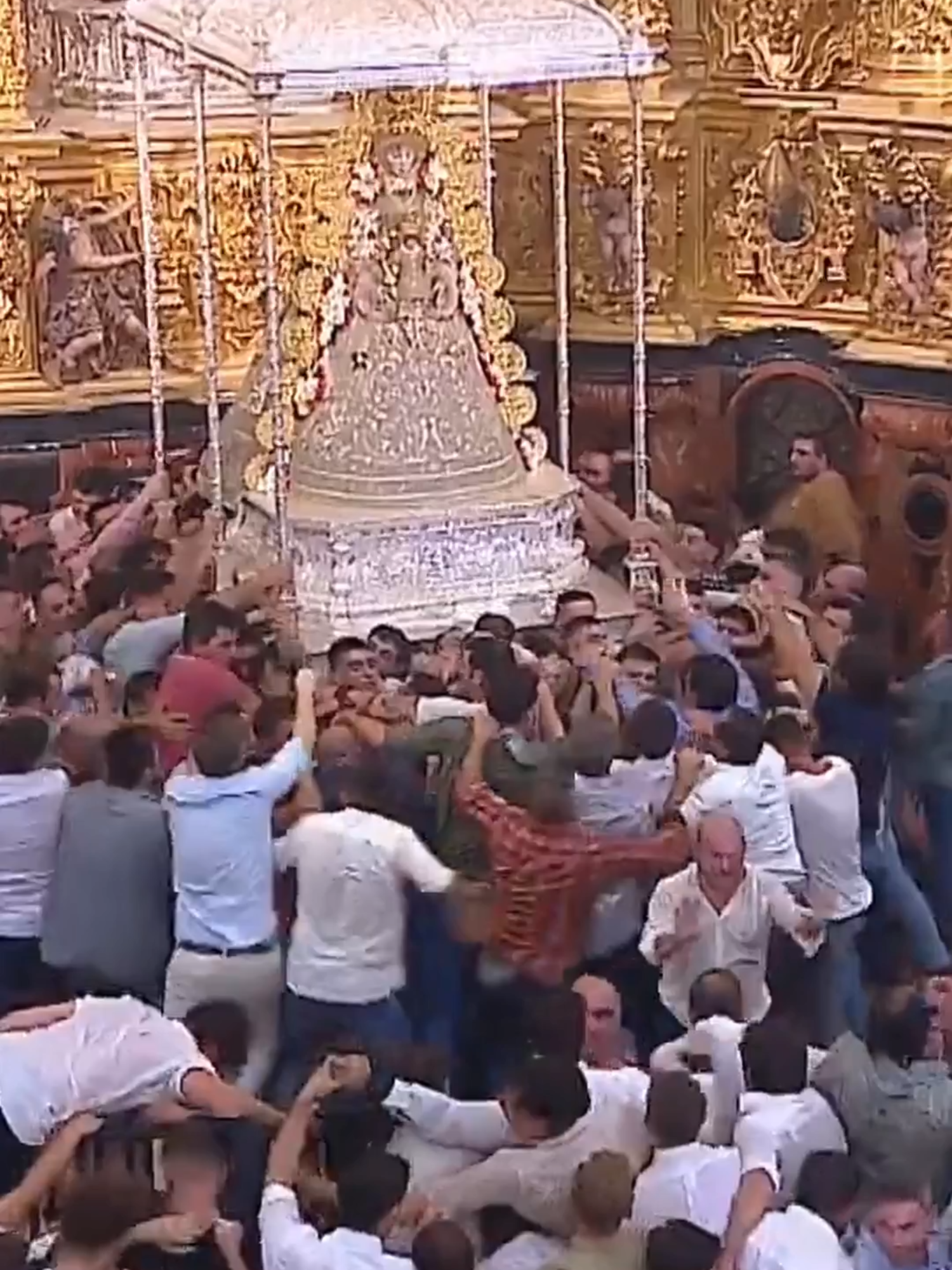 Los almonteños saltan la reja a las 2:42 de la madrugada. Accedían al presbiterio para coger en andas a la Virgen del Rocío. Poco después cruzaba el pórtico de la concha. Ésta ha sido una de las salidas más tempraneras de este siglo, entre el sonido del repique de campanas de la ermita y los continuos vítores y palmas dan paso. El 'salto' ha tenido lugar 15 minutos antes que el año pasado -2:57- y apenas cuatro minutos después, a hombros de los almonteños, la Virgen ha alcanzado el pórtico del Santuario para salir a una explanada frontal en la que la esperaban miles de fieles. Tras salir de la ermita, se ha dirigido, como es tradicional, a su lateral izquierdo, el de la marisma, para empezar a visitar a sus 127 hermandades filiales -la primera de ellas la de Huévar del Aljarafe (Sevilla)-en un paseo que concluirá cuando decida el pueblo de Almonte y que este año se ha ampliado a su llegada a la Plaza Doñana para darle más agilidad. Una ampliación que permitirá, además, vivir momentos hasta ahora inéditos como el paso de la Virgen por la puerta de la casa de la Hermandad de Sevilla. Para la ocasión, la Blanca Paloma y el 'Pastorcito' lucen el conjunto textil de 