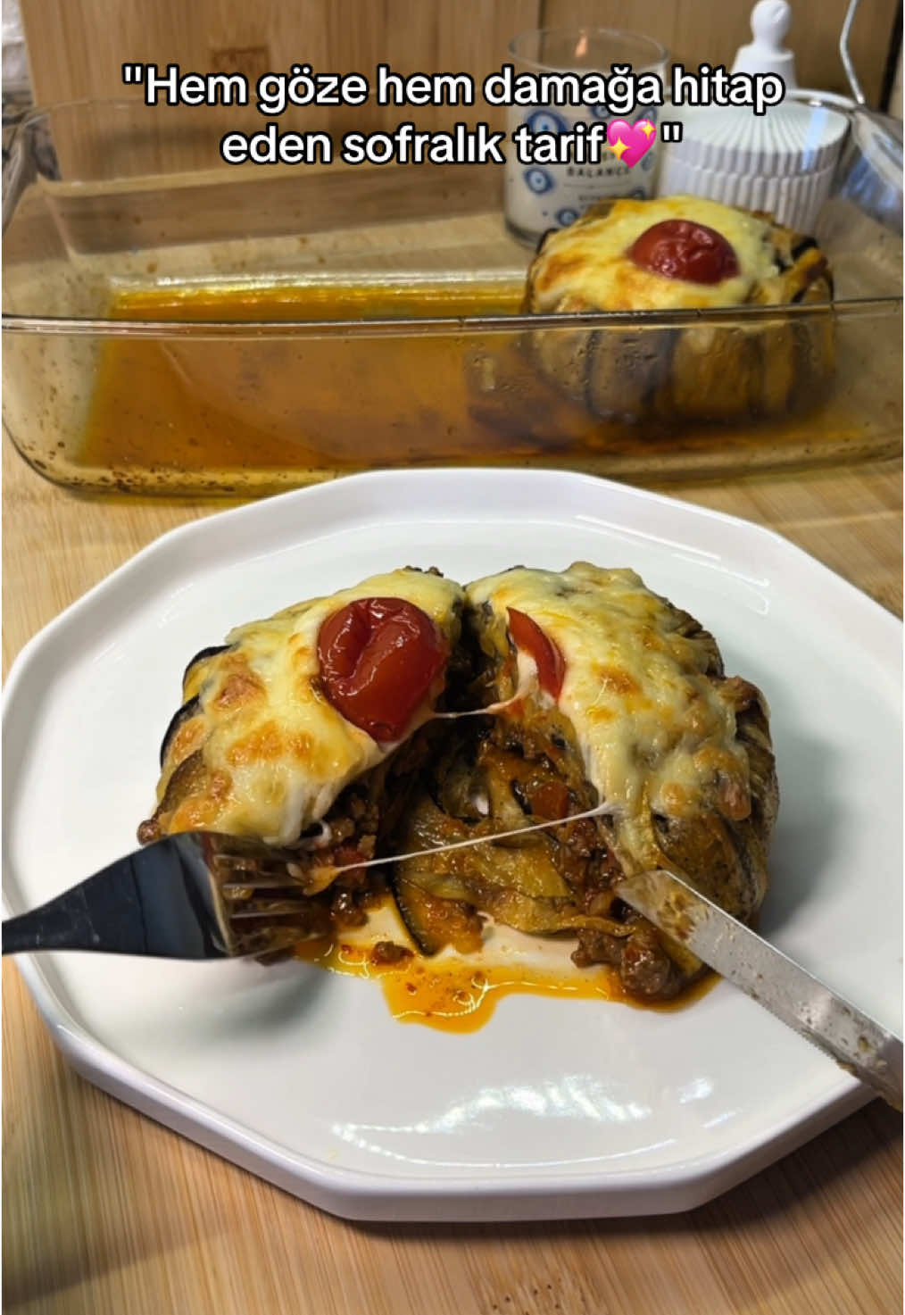 Misafir sofralarına şıklık katan, lezzetiyle herkesin bayıldığı patlıcanlı mini güveçler! İncecik fırınlanmış patlıcanların içine saklanan yumuşacık kıymalı harç ve üzerindeki erimiş kaşar… Her lokması ayrı bir ziyafet! 😍 Malzemeler: 4 adet patlıcan 300 gr kıyma 1 adet kuru soğan 2 adet yeşil biber 1 adet kapya biber 2 adet domates (kabukları soyulmuş) 1 yemek kaşığı domates salçası Tuz, karabiber, pul biber, kimyon Zeytinyağı Kaşar peyniri (rendelenmiş) ⸻ Hazırlanışı: 1. Patlıcanları uzunlamasına ince dilimleyin (çok kalın olmasın, kolay şekil alsın). Tuzlu suda 15 dakika bekletin, süzüp kuruladıktan sonra her iki yüzünü toz kırmızı biber eklediğiniz zeytinyağı ile yağlayın. Önceden ısıtılmış 200 derece fırında, altın rengini alana kadar yaklaşık fırınlayın. Ayrı bir yerde ay şeklinde doğradığınız patatesleri derin yağda kızartın. 2. Tavaya biraz zeytinyağı alın, yemeklik doğradığınız soğanı kavurun. Küp doğranmış biberleri ekleyip soteleyin. Kıymayı ekleyin, suyunu salıp çekene kadar pişirin. Salçayı ekleyip karıştırın, doğranmış domatesleri ekleyin. Tuz, karabiber, pul biber ve kimyon ile yarım su bardağı kaynar su ekleyerek harcı lezzetlendirin. Kısık ateşte harç suyunu çekene kadar pişirin. 3. Mini güveç kaplarının tabanına fırınladığınız patlıcan dilimlerini videodaki gibi dizin, uçları kapların dışına taşsın (sonradan üstünü kapatacağız). Ortasına kıymalı harçtan doldurun.Patlıcanların dışta kalan uçlarını harcın üzerine kapatın. 4. Güveçleri fırın tepsisine ters çevirin. Üzerine rendelenmiş kaşar peyniri serpin. 5. Önceden ısıtılmış 200 derece fırında kaşarlar eriyip kızarana kadar (yaklaşık 10–15 dakika) fırınlayın Deneyenlere afiyet olsun💖 • • • #patlican #patlıcangüveç #patlıcanlıyemekler #anayemekler #bugünnepişirsem #kiymali #kıymalı #kıymalıyemekler #patlıcan #yemeksunumu #patlıcanlıtarifler #sebzeyemeği #sebzeyemekleri #etliyemekler #lezzetliyemekler #nefispratikyemekler #evyemekleri̇ #lezzetli_tariflerle #tarif #kolayyemektarifleri #reels #reelsyemek #keşfet #keşfetteyi̇z #tarifdefterim #foodreels #likeforlikeback #fouryoupage #dinneridea #turkishfood #tiktokindia #tiktokviral #tik_tok 